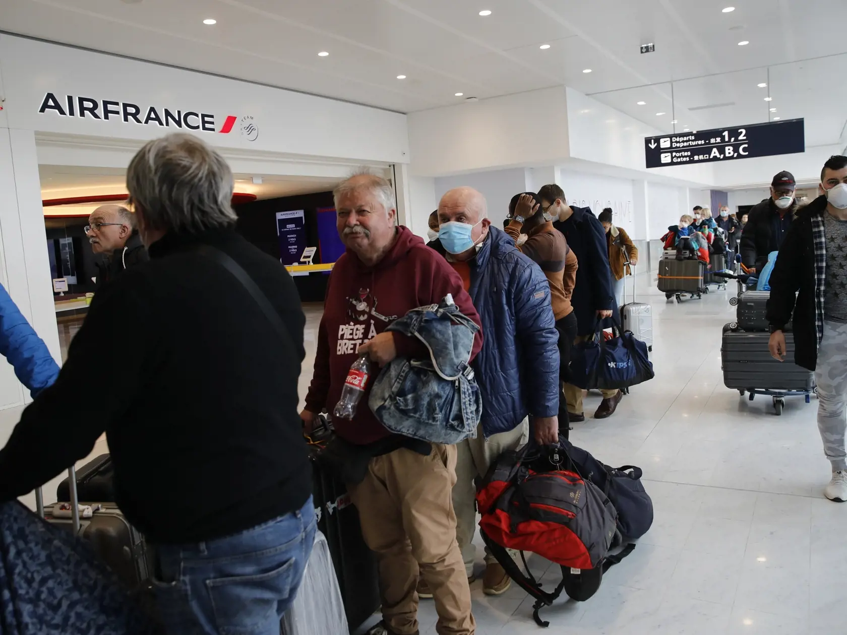KK17 Paríž - Cestujúci čakajú v rade na letisku v Paríži  v utorok 17. marca 2020. Francúzsky prezident Emmanuel Macron nariadil v pondelok ľuďom, aby od utorkového poludnia zostali doma, s výnimkou nevyhnutných dôvodov ako napríklad nákup. Macron upozornil, že porušenie týchto sprísnených pravidiel, zameraných na boj proti novému koronavírusu, bude potrestané. Dodal, že Európska únia sa dohodla na zatvorení svojich vonkajších hraníc na nasledujúcich 30 dní. FOTO TASR/AP
Travelers wait in line a