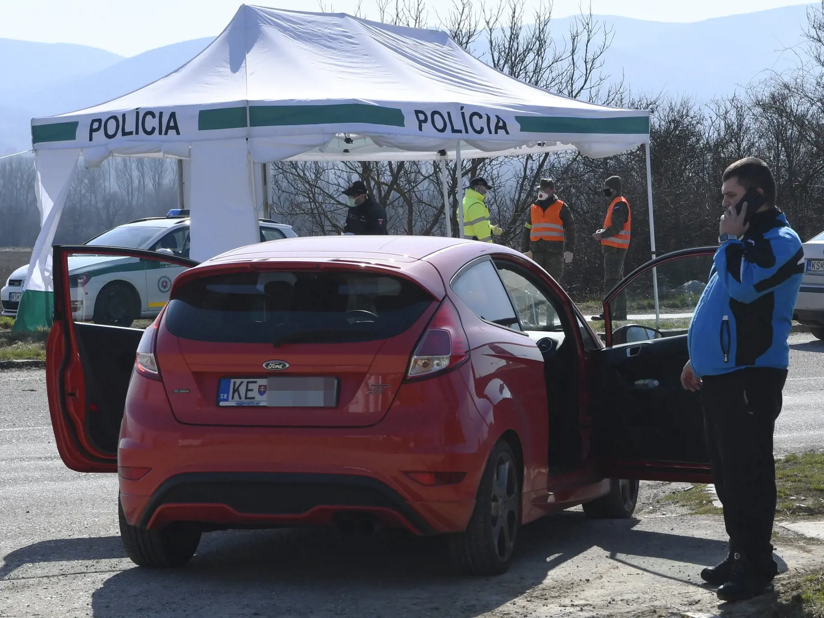 Policajná kontrola áut na novom priechode Milhosť-Tornyosnémeti na slovensko-maďarskej hranici  v okrese Košice - okolie 17. marca 2020. Kamióny po kontrole bez dlhšieho zdržania pustili na Slovensko. Zo Slovenska do Maďarska prechádzali priebežne bez kontroly. Tieto opatrenia boli prijaté k obmedzeniu rozšírenia koronavírusu. Na snímke občan SR zisťuje momentálny stav a možnosť cestovania cez hranice do Maďarska. FOTO TASR – Milan Kapusta