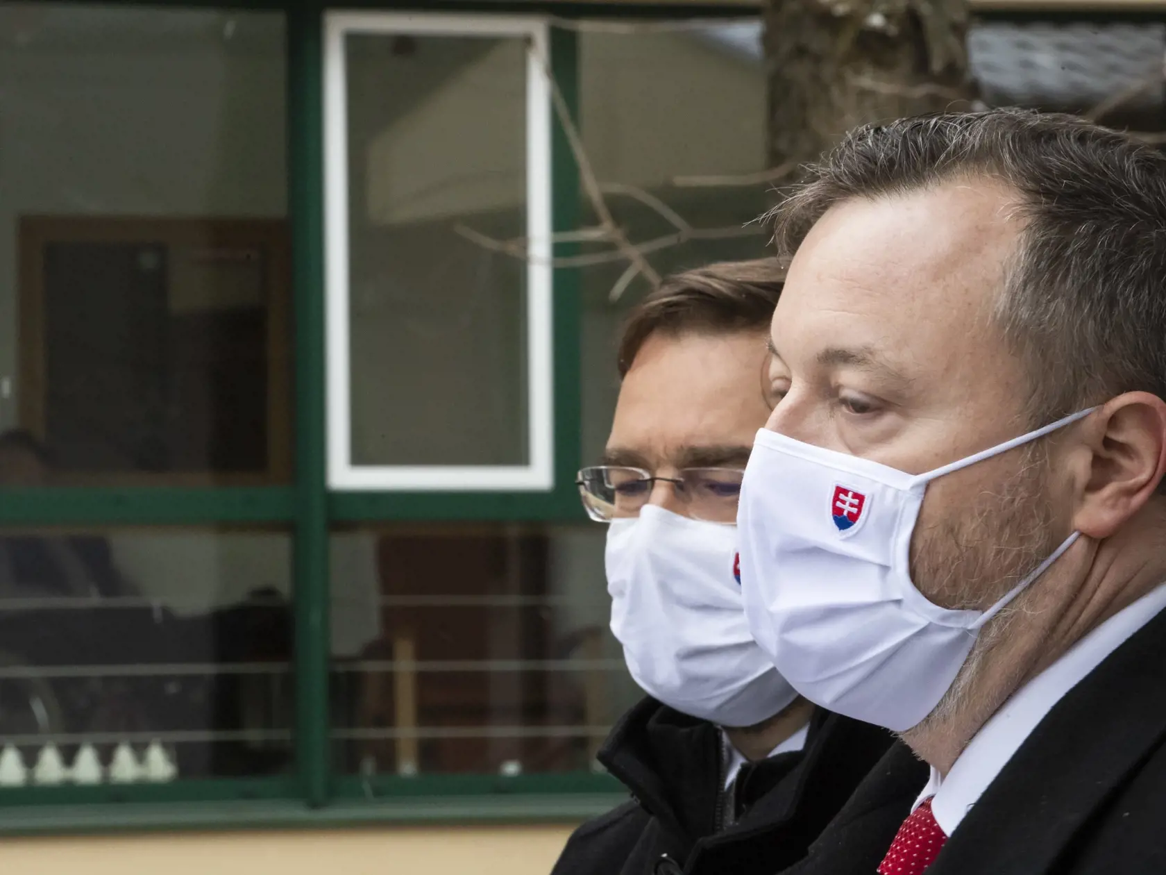 Na snímke zľava minister zdravotníctva SR Marek Krajčí, minister práce, sociálnych vecí a rodiny SR Milan Krajniak a v pozadí Petržalský domov seniorov na Vilovej ulici počas tlačového brífingu k pilotnému očkovaniu zamestnancov a klientov v zariadeniach sociálnych služieb (ZSS) v Bratislave 18. januára 2021. FOTO TASR - Jaroslav Novák