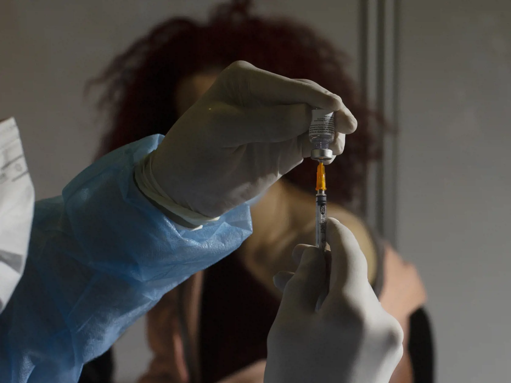 Zdravotník naťahuje do injekčnej striekačky vakcínu proti ochoreniu Covid-19 od spoločnosti Pfizer vo vakcinačnom centre 14. januára 2021 v Jeruzaleme.