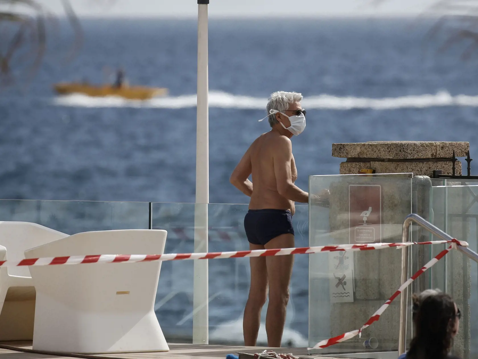 WA 28 Tenerife - Turista s ochranným rúškom na tvári sa pozerá na more v priestore Hotela H10 Costa Adeje Palace v letovisku Adeje na juhozápade španielskeho ostrova Tenerife v piatok 28. februára 2020. Španielske úrady povolili približne 130 hosťom opustiť hotel, ktorý je v karanténe v súvislosti s nákazou spôsobenou novým koronavírusom SARS-CoV-2 . Hoteloví hostia, ktorých bolo približne 1000 boli do karantény umiestnení v utorok. Stalo sa tak potom, čo mal taliansky lekár, ktorý sa v hotelovo