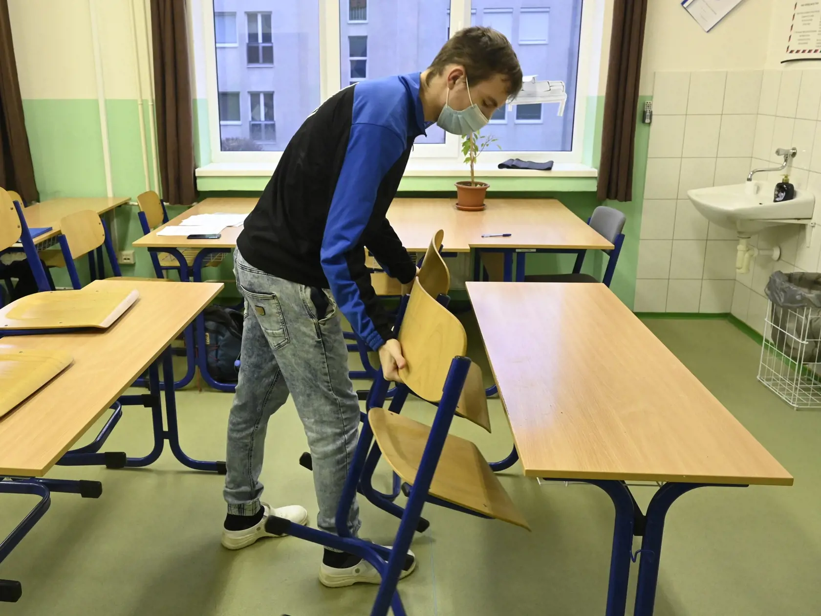 Študent pripravuje triedu na obnovené vyučovanie v jednej z tried Strednej zdravotníckej školy Celestíny Šimurkovej v Trenčíne, 8. februára 2021. Trenčiansky samosprávny kraj otvoril stredné školy pre študentov končiacich ročníkov v šiestich z deviatich svojich okresov. FOTO TASR - Radovan Stoklasa