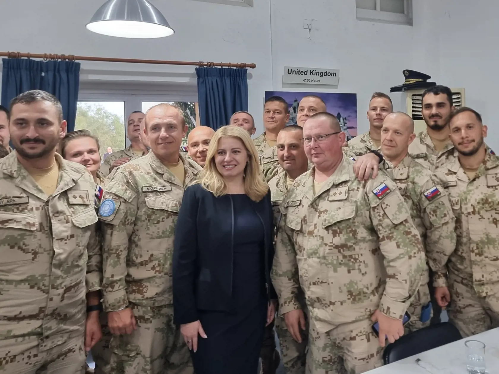Prezidentka Zuzana Čaputová (uprostred) a príslušníci Ozbrojených síl SR pôsobiaci na Cypre pózujú počas stretnutia v Nikózii v pondelok 12. decembra 2022.