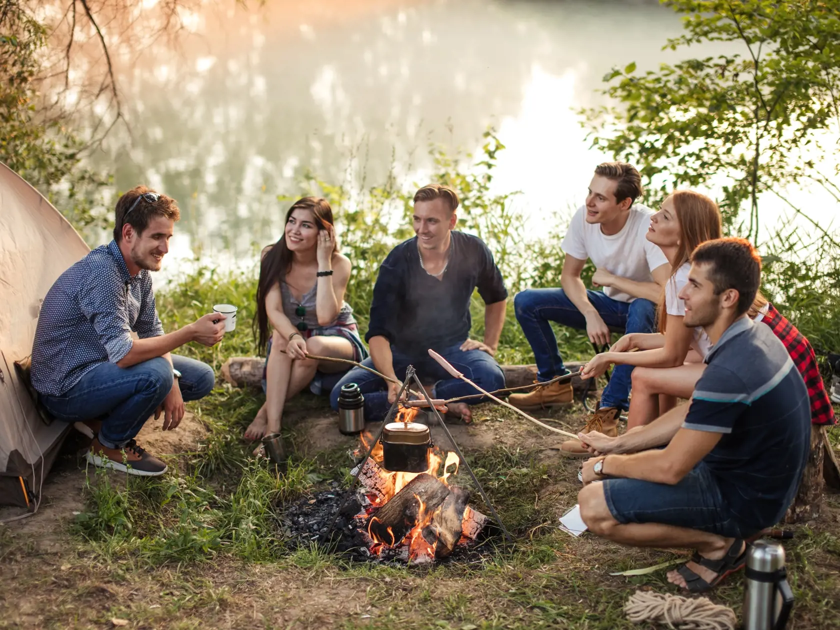 Young,Attractive,People,Holding,Sticks,With,Sausages,On,The,Bonfire.