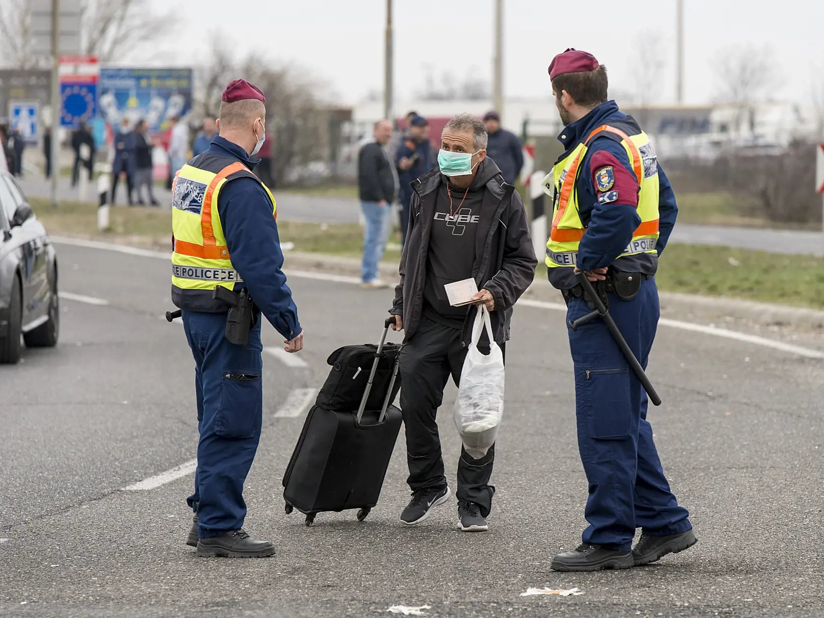WA 19 Hegyeshalom - Policajti kontrolujú cudzincovi doklady na uzavretom rakúsko-maďarskom hraničnom priechode pri Hegyeshalome 17. marca 2020. Maďarsko pre hrozbu šírenia nového koronavírusu SARS-CoV-2 zatvorilo svoje hranice. Maďarské a rumunské policajné zložky sa podľa hovorcu krízového štábu Tibora Lakatosa dohodli, že v utorok v noci v určenom čase umožnia občanom Rumunska a Bulharska precestovať cez maďarské územie, ale iba po vyznačenej trase. Na rakúsko-maďarskom hraničnom priechode pri