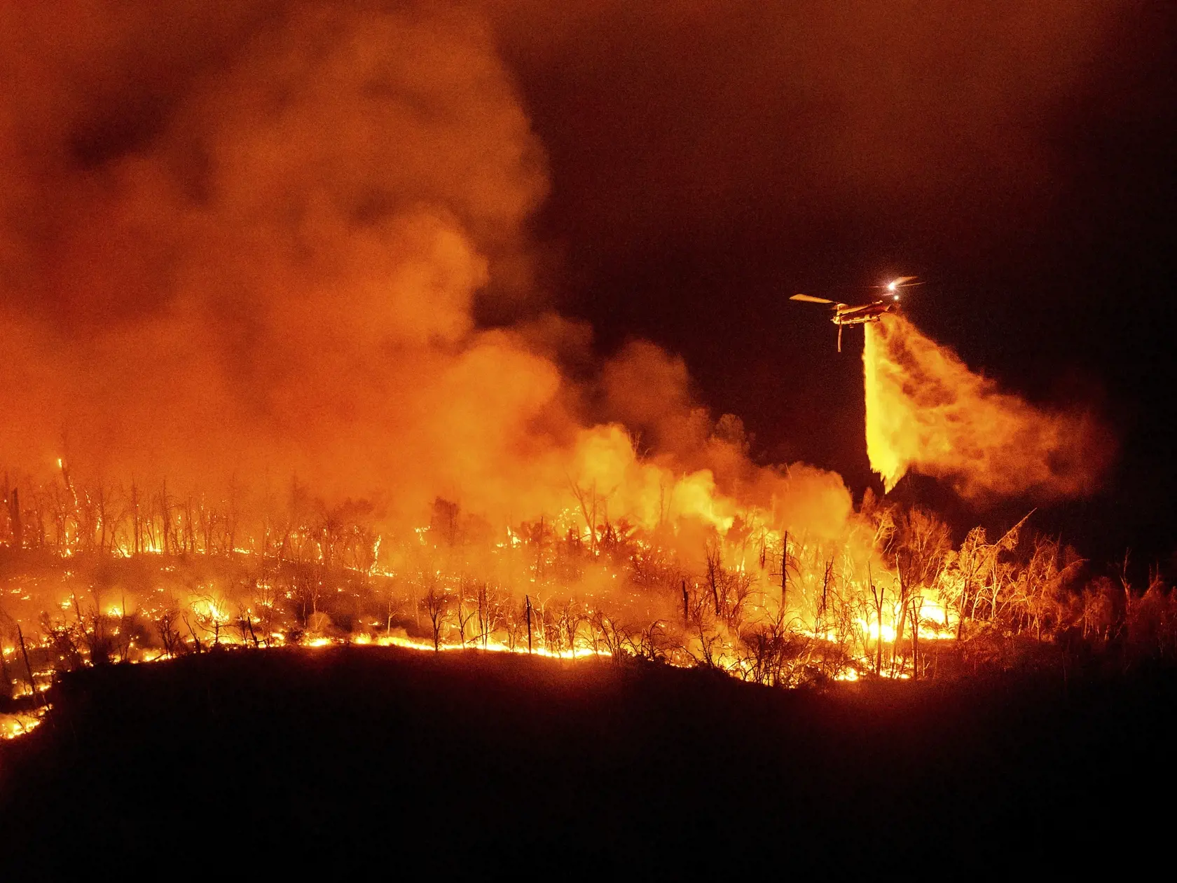 KK6 Oroville - Vrtuľník zhadzuje vodu počas hasenia lesného požiaru nad jazerom Oroville v kalifornskom Oroville 2. júla 2024. FOTO TASR/AP
A helicopter drops water on the Thompson Fire as it burns above Lake Oroville in Oroville, Calif., Tuesday, July 2, 2024.  (AP Photo/Noah Berger)