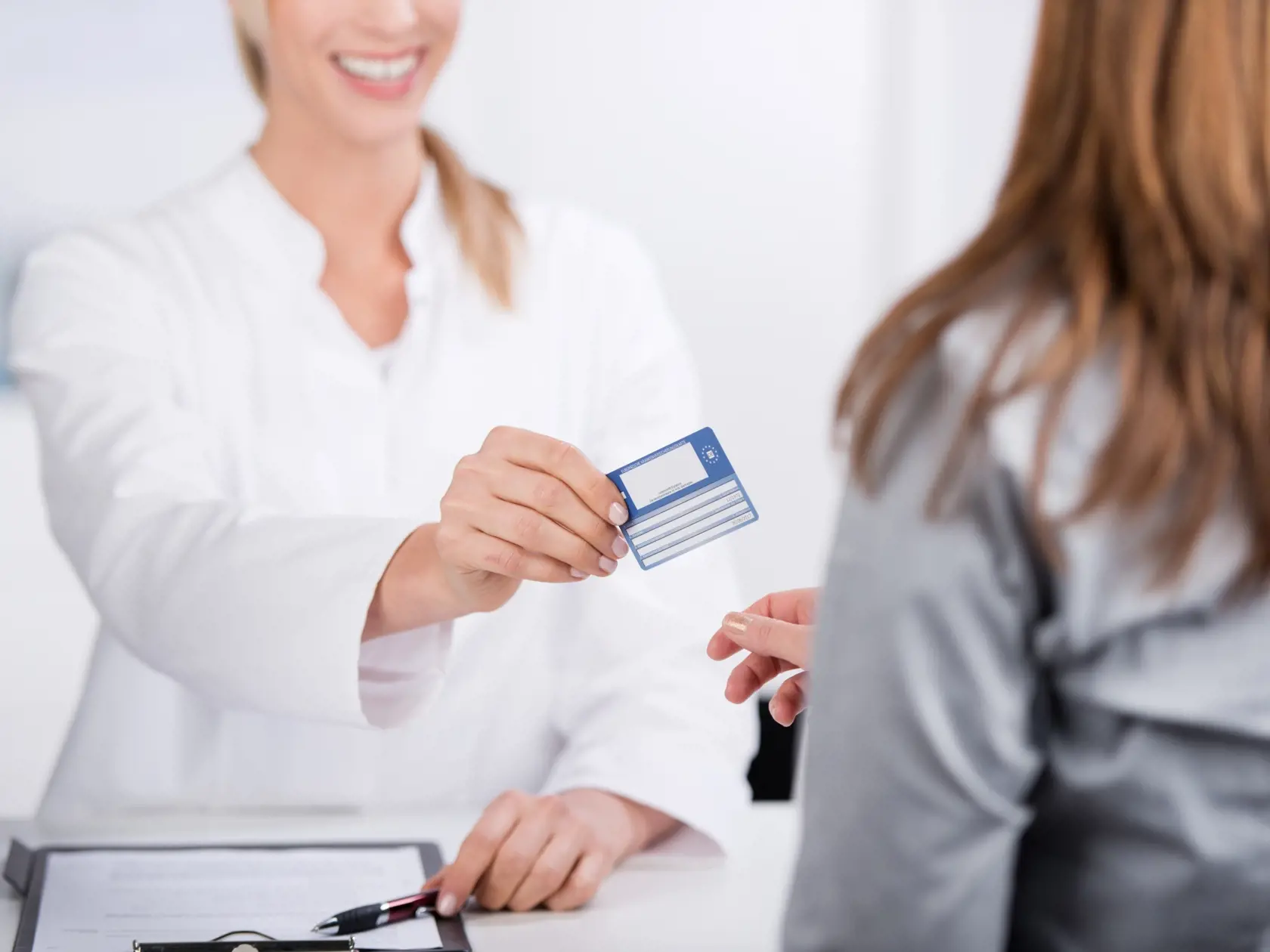 Smiling,Young,Doctor,Giving,Health,Card,To,A,Patient