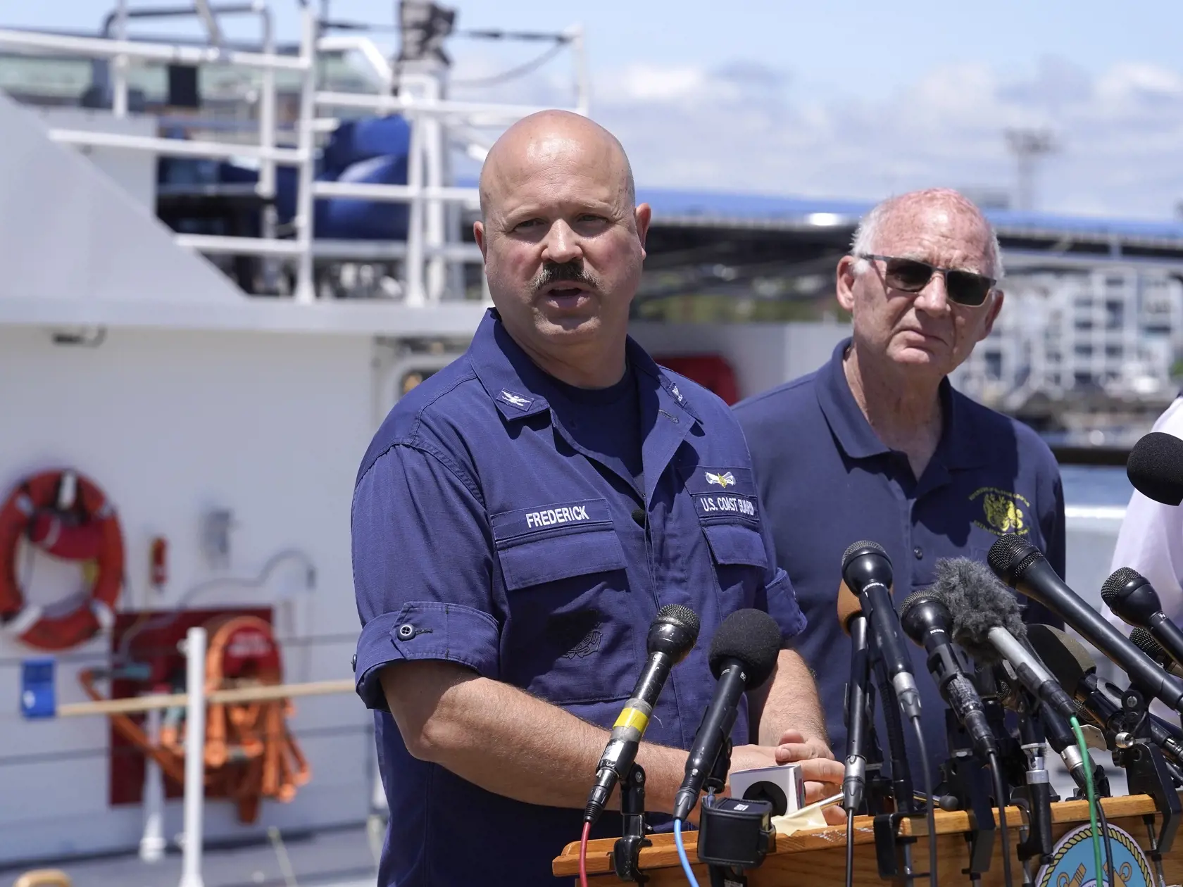 WA 53 Boston - Kapitán americkej pobrežnej stráže (USCG) Jamie Frederick (vľavo) odpovedá na otázky novinárov na tlačovej konferencii v Bostone v stredu 21. júna 2023. USCG nasadila v severnej časti Atlantického oceánu ďalšie lode a podmorské plavidlá. Pátrajú po miniponorke Titan po tom, ako záchranári pod vodou zaznamenali zvuky. Titan a jeho posádka je nezvestná od nedele 18. júna. Výletná ponorka Titan sa stratila v nedeľu počas plavby k vraku parníka Titanic. Ten leží na dne v hĺbke 3800 me