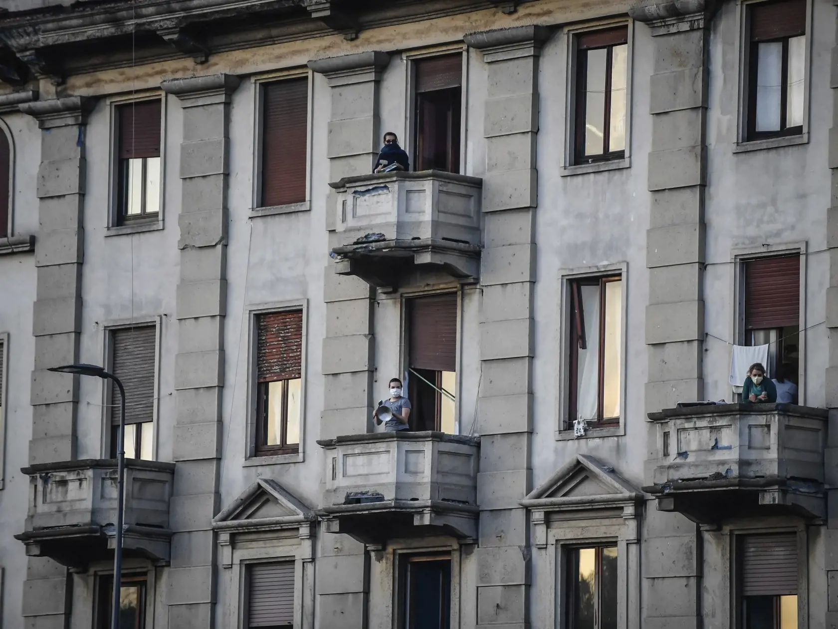 KK34 Miláno - Ľudia na svojich balkónoch hrajú a spievajú počas hromadnej akcie, ktorú spustili v Taliansku s cieľom spojiť ľudí a zvládnuť núdzový stav kvôli novému koronavírusu 13. marca 2020 v Miláne. FOTO TASR/AP
People lean out of their home's balconies to play and sing during a flash mob launched throughout Italy to bring people together and try to cope with the emergency of coronavirus, in Milan, Italy, Friday, March 13, 2020. Italians have been experiencing yet further virus-containment 