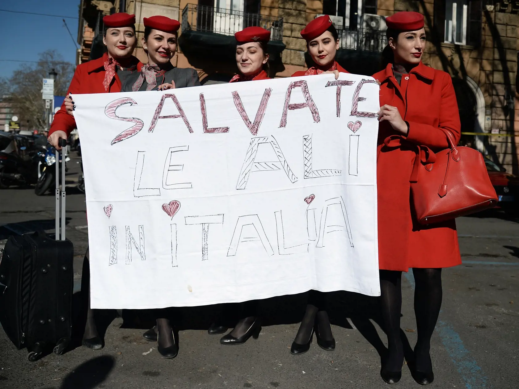 KK34 Rím - Zamestnankyne  leteckej spoločnosti Air Italy protestujú pred ministerstvom dopravy v Ríme 20. februára 2020. Akcionári regionálnych aerolínií Air Italy, ktoré patria ku Qatar Airways, oznámili ich likvidáciu. Air Italy so sídlom v meste Olbia na Sardínii zamestnáva 1400 ľudí. Podľa expertov je dôvodom krachu spoločnosti konkurencia nízkonákladových aerolínií rovnako ako štátom podporovanej Alitalie. FOTO TASR/AP
Air Italy employees stand behind a banner with writing reading in Italia
