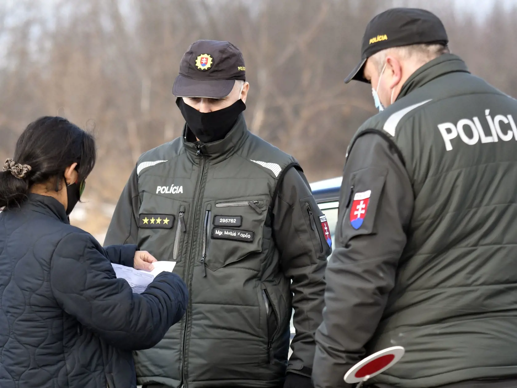 V rómskej osade v obci Sačurov v okrese Vranov nad Topľou po pretestovaní obyvateľov antigénovými testami odhalili 113 prípadov na ochorenie Covid-19. Na dodržiavanie karantény v rómskej osade dohliadajú od štvrtka rána policajti, popoludní hliadky posilnili i vojaci. Na snímke policajti kontrolojú potvrdenie o teste pred rómskou osadou v obci Sačurov 4. februára 2021. FOTO TASR - Roman Hanc