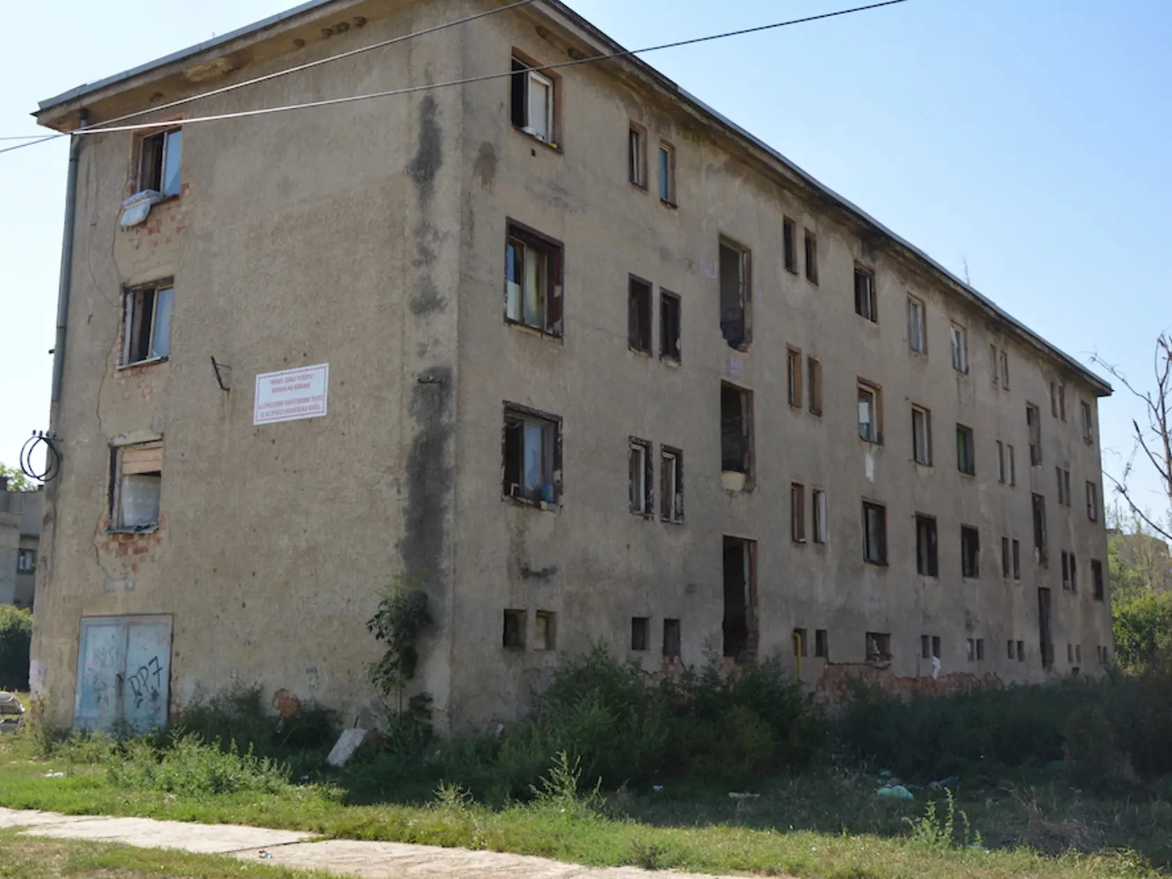 Zdemolovaná bytovka je určená na zbúranie, napriek zákazu v nej stále bývajú rodiny aj s malými deťmi.