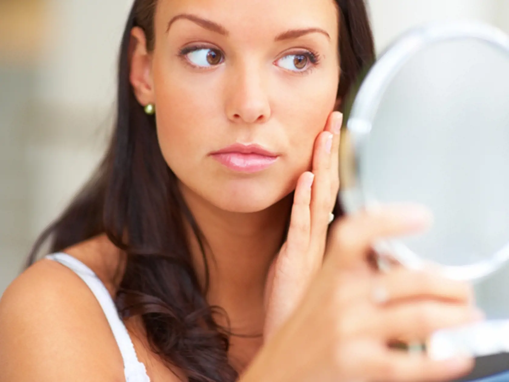 Closeup portrait of young lady holding a mirror
