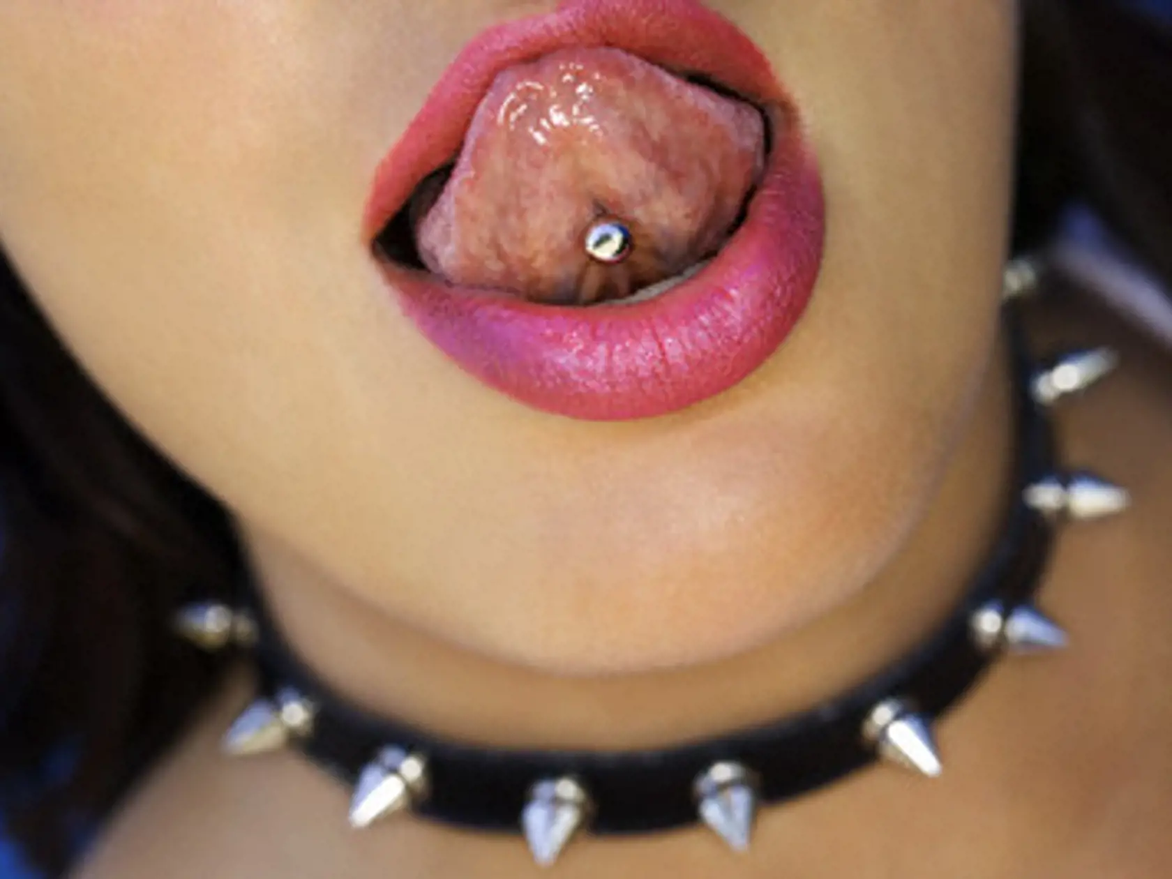 Maui, Hawaii, USA --- Woman With Studded Collar and Pierced Tongue --- Image by © Thinkstock/Corbis
