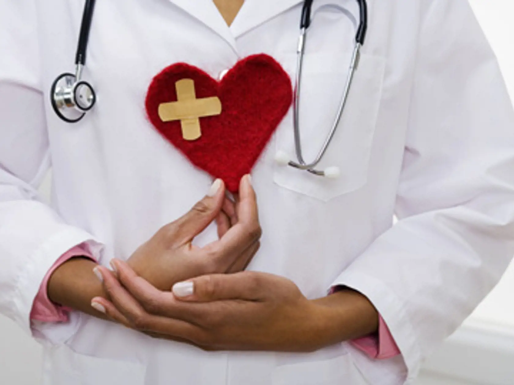 Doctor holding heart with bandage
