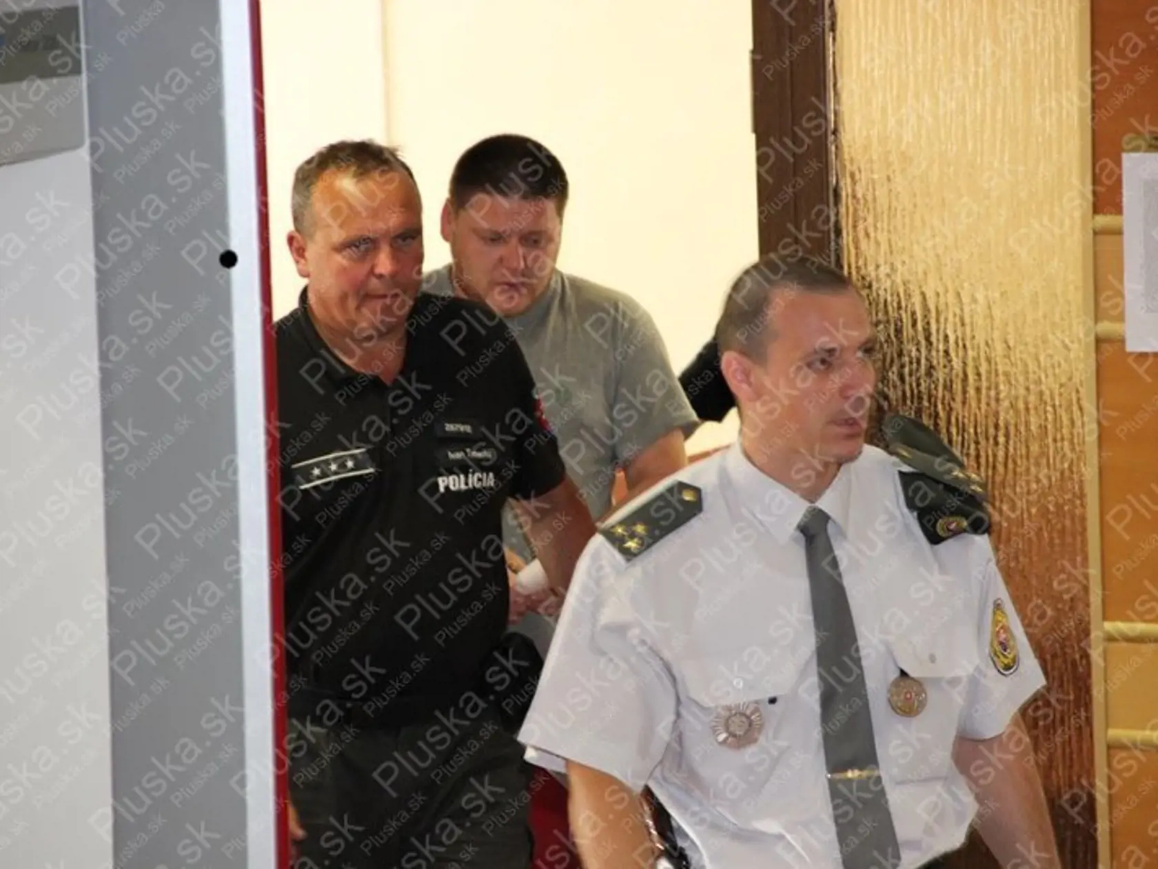 Peter v sprievode polície vchádza do súdnej siene.