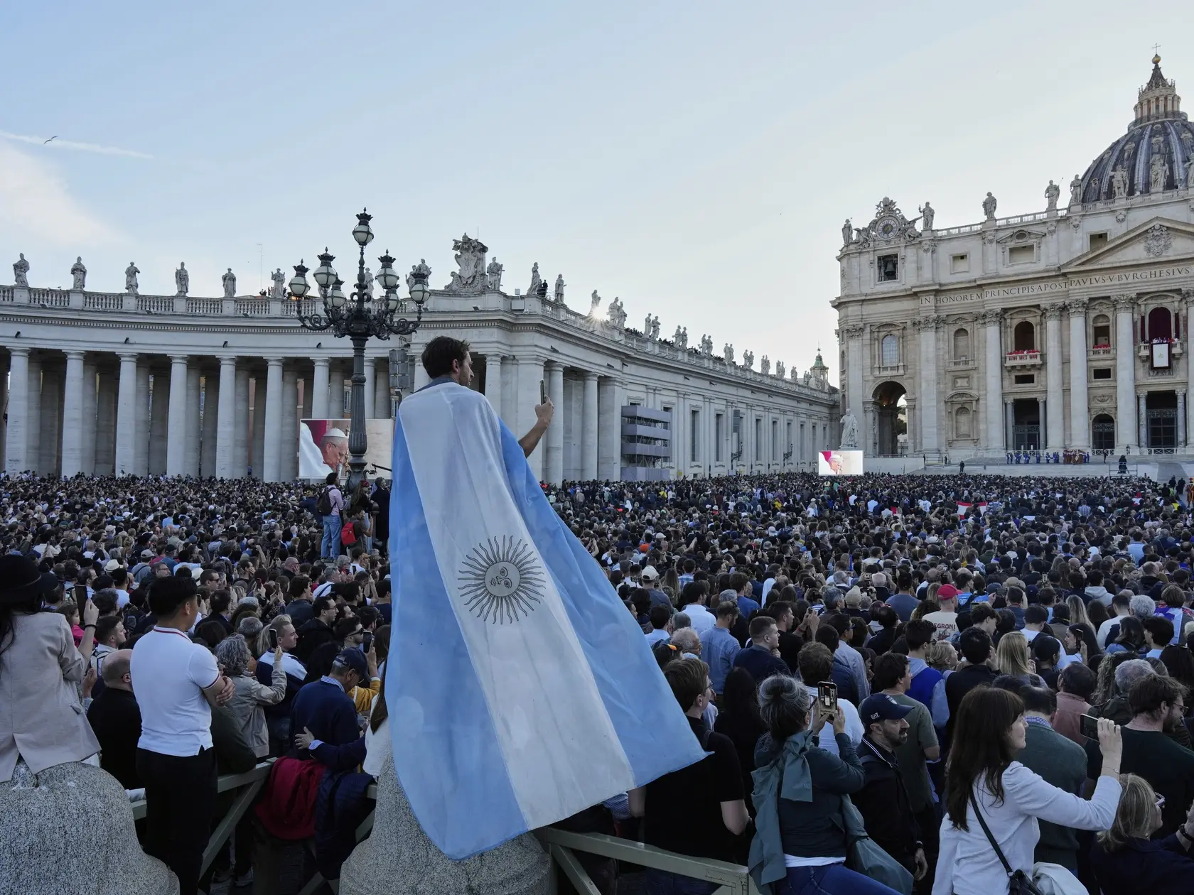 JB 85 Vatikán - Ľudia sledujú na Svätopeterskom námestí príhovor novozvoleného pápeža Leva XIV., bývalého amerického kardinála Roberta Prevosta, ktorý sa objavil na centrálnom balkóne Baziliky Sv. Petra po tom, ako ho kardináli zvolili za nového pápeža po troch kolách hlasovania počas konkláve vo Vatikáne vo štvrtok 8. mája 2025. Amerického kardinála Roberta Prevosta zvolilo vo štvrtok konkláve za 267. pápeža katolíckej cirkvi v poradí. Zvolený pápež prijal meno Lev XIV., informuje TASR. Kardináli-voliči dvojtretinovou väčšinou zvolili počas druhého dňa konkláve 267. pápeža katolíckej cirkvi. Nový pápež nahradí svojho predchodcu Františka, ktorý zomrel na Veľkonočný pondelok 21. apríla. FOTO TASR/AP

People watch the newly elected Pope Leone XIV as he appears at the balcony of St. Peter's Basilica at the Vatican, Thursday, May 8, 2025. (AP Photo/Bernat Armangue)