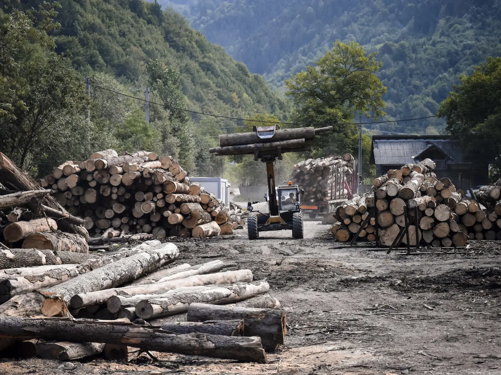 Na archívnej z 23. augusta 2021 traktor presúva drevo v sklade dreva pri Viseu de Sus v Marmarošských vrchoch na severe Rumunska. Ekologický aktivisti obviňujú Rumunsko, že nedokáže zastaviť nezákonný výrub lesov a poškodzovanie prírody na územiach chránených európskymi zákonmi. Pred dvoma rokmi dostalo Rumunsko právne varovanie z Bruselu, aby nezákonné odlesňovanie zastavilo. FOTO TASR/AP