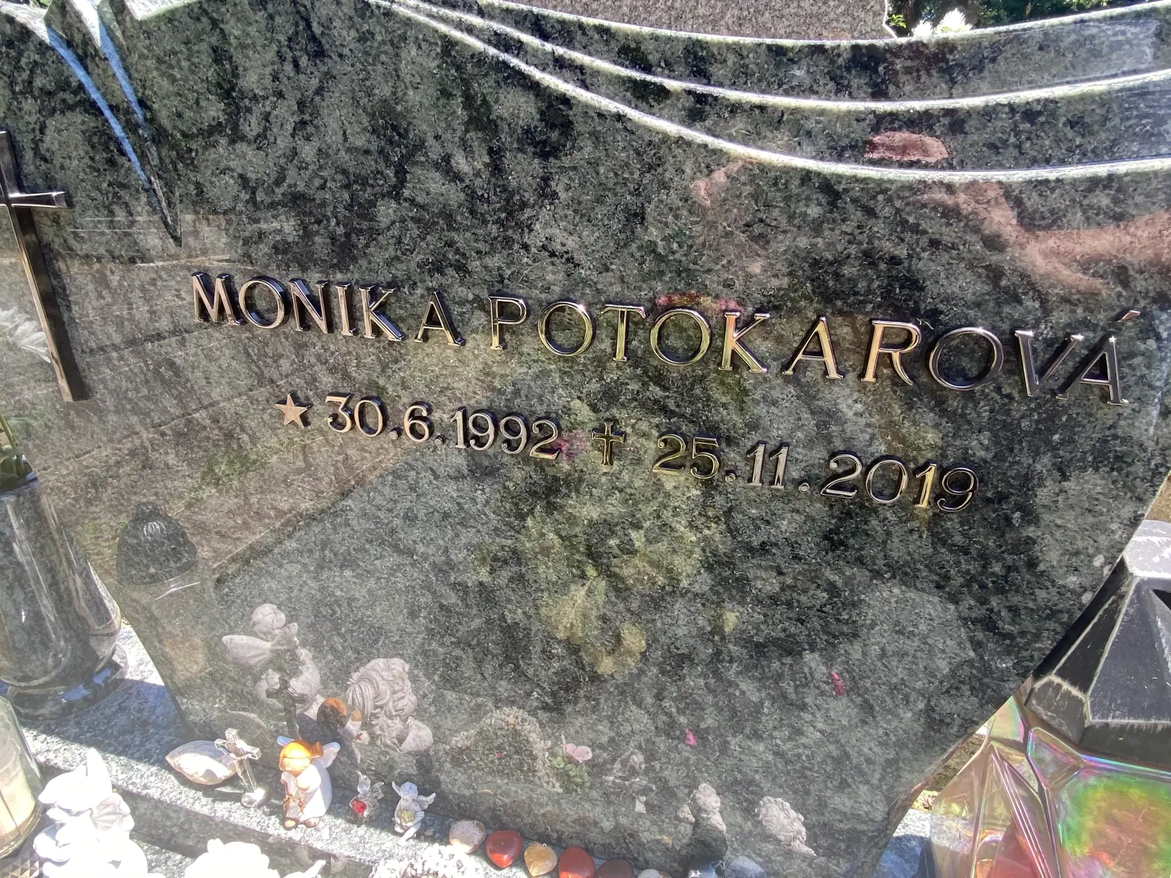 Monika Potokárová. Pri istom uhle sa podarí text na náhrobnom kameni odfotografovať.