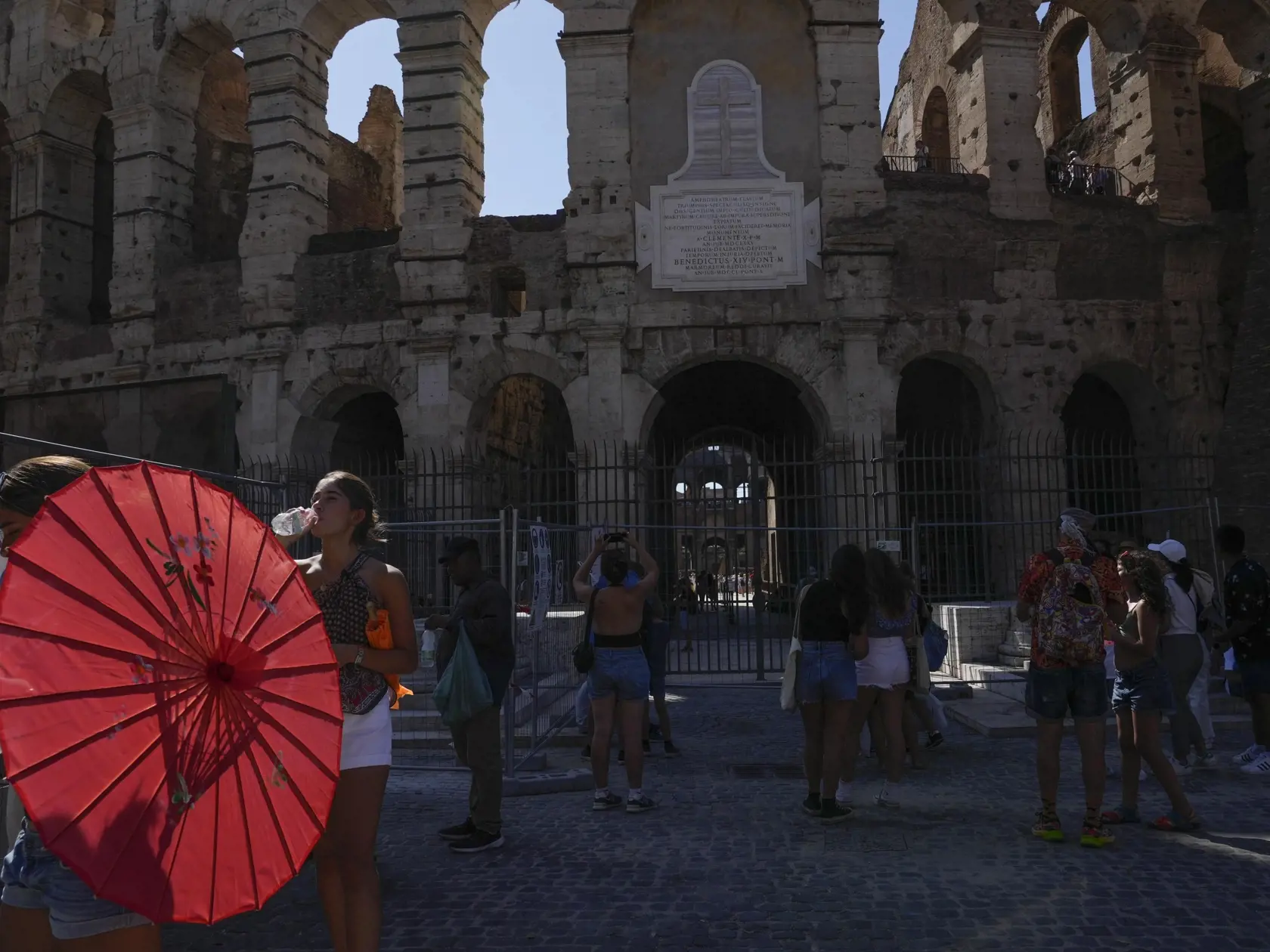 Turisti pijú studenú vodu počas horúčav pred Koloseom v Ríme 5. júla 2023.