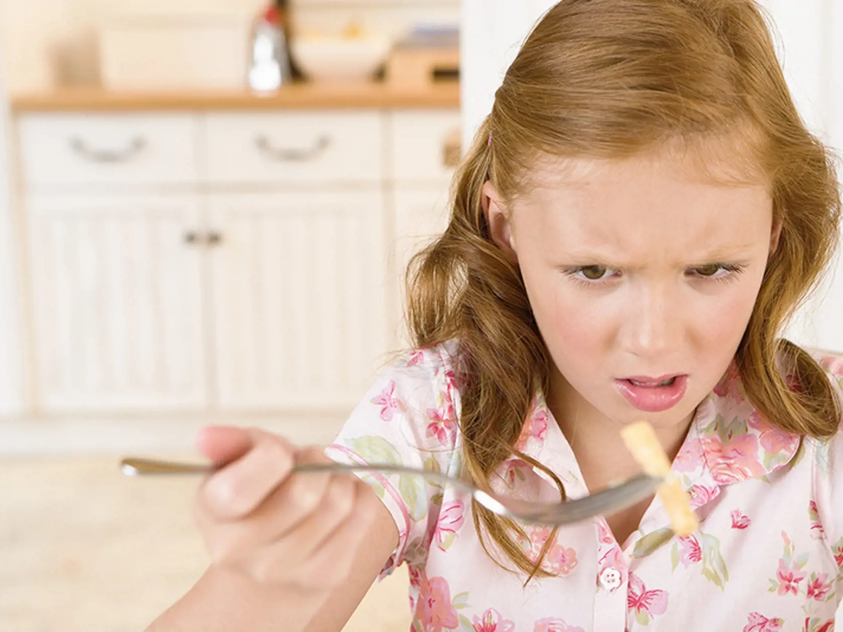 Upset girl eating pasta