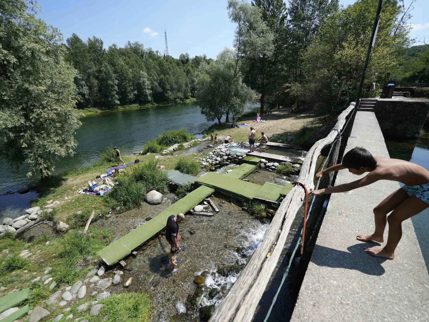 EBE 14 Cornate D'Adda - Ľudia sa ochladzujú v umelých bazénoch, ktoré postavili dobrovoľníci v obci Cornate D'Adda na rieke Adda na severe Talianska 13. júla 2022. Očakáva sa, že teploty v Taliansku vystúpia až na 38 stupňov Celzia. FOTO TASR/AP

People cool off in pools realized by volunteers in Cornate D'Adda, on the Adda river, northern Italy, Wednesday, July 13, 2022. Temperatures in Italy are expected to rise up to 38 degrees Celsius (100,4 degrees Fahrenheit). (AP Photo/Luca Bruno)