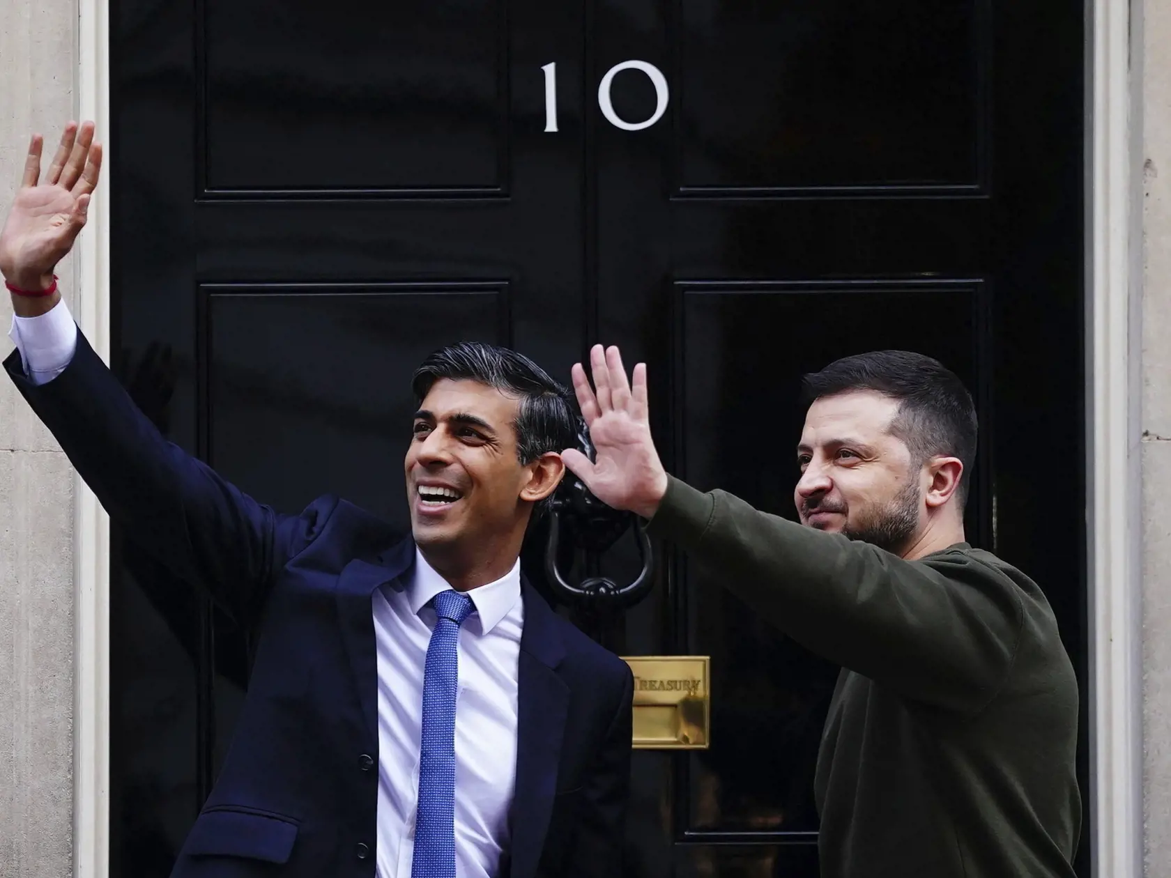 WA 50 Londýn - Ukrajinský prezident Volodymyr Zelenskyj (vpravo) a britský premiér Rishi Sunak mávajú na Downing Street 10 v Londýne v stredu 8. februára 2023. Ide o Zelenského prvú návštevu v Británii od začiatku invázie Ruska na Ukrajinu. Britská vláda o nej informovala v stredu ráno.  Najvyšší ukrajinský predstaviteľ absolvuje aj audienciu u britského kráľa Karola III., prihovorí sa k britskému parlamentu, uviedla vo vyhlásení britská vláda. Stretne sa i s ukrajinskými vojakmi, ktorí sa cviči