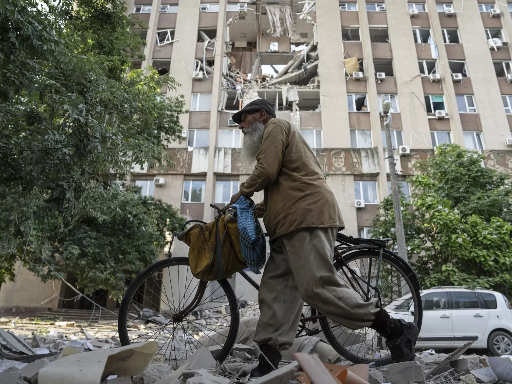 WA 7 Cherson - Muž kráča s bicyklom okolo budovy, ktorú zničil ruský raketový útok v meste  Cherson na juhu Ukrajiny vo štvrtok 15. júna 2023. FOTO TASR/AP 

A man walks in front of a building which was heavily damaged by a Russian airstrike in Kherson, Ukraine, Thursday, June 15, 2023. (AP Photo/Evgeniy Maloletka)