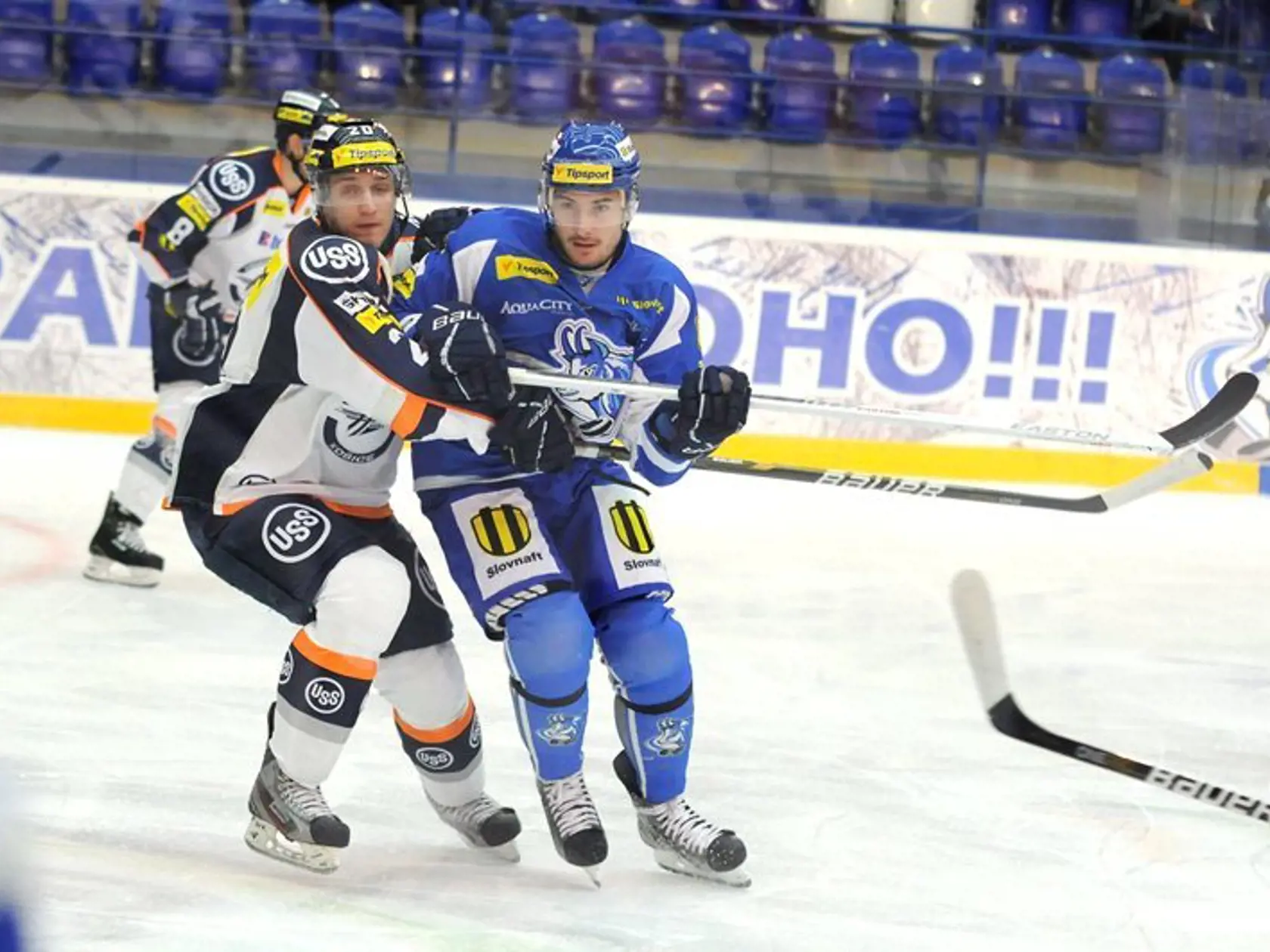 Dominik Riečický z Košíc (vľavo) v súboji s Romanom Tomasom z Popradu (vpravo) počas zápasu 2. kola slovenskej hokejovej Tipsport extraligy medzi HK Poprad a HC Košice.