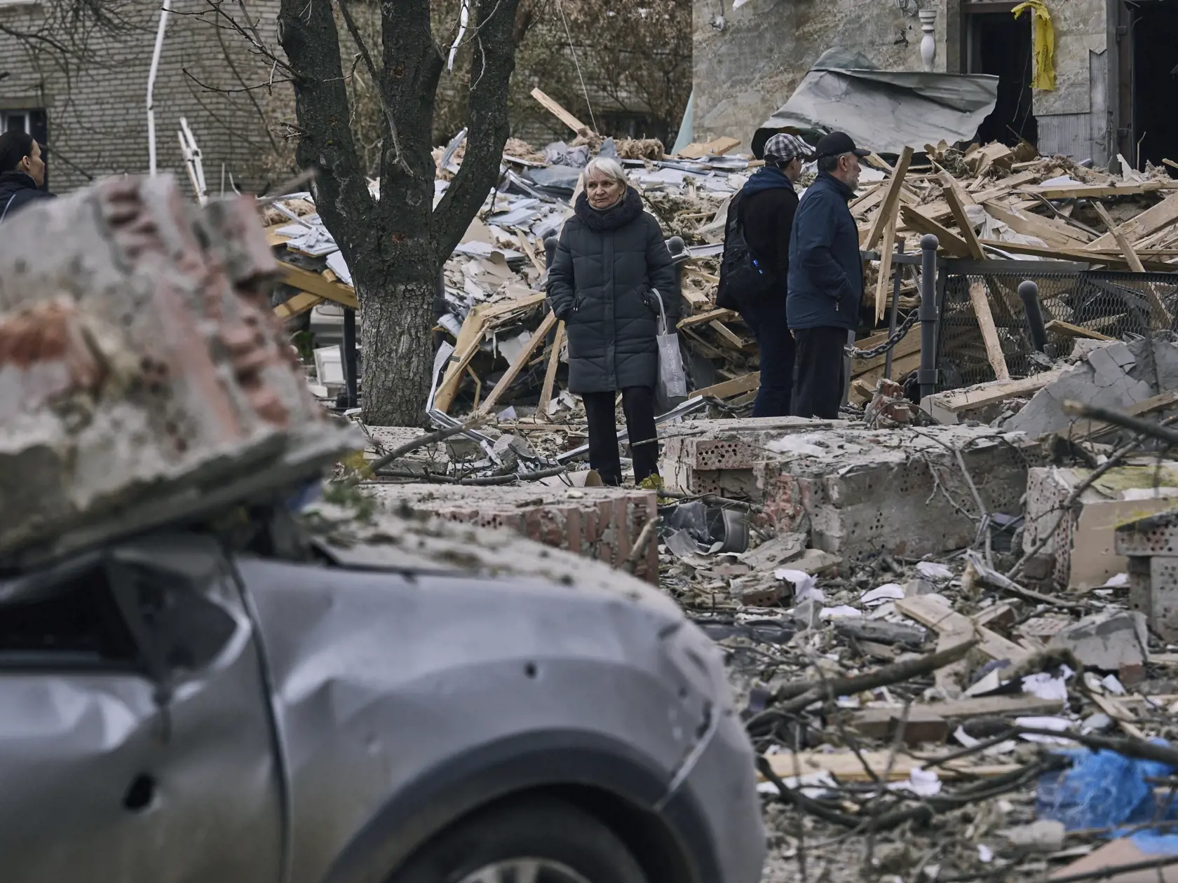 Na snímke ľudia stoja pred zničenou budovou po ruskom útoku v ukrajinskom meste Sloviansk 27. marca 2023.