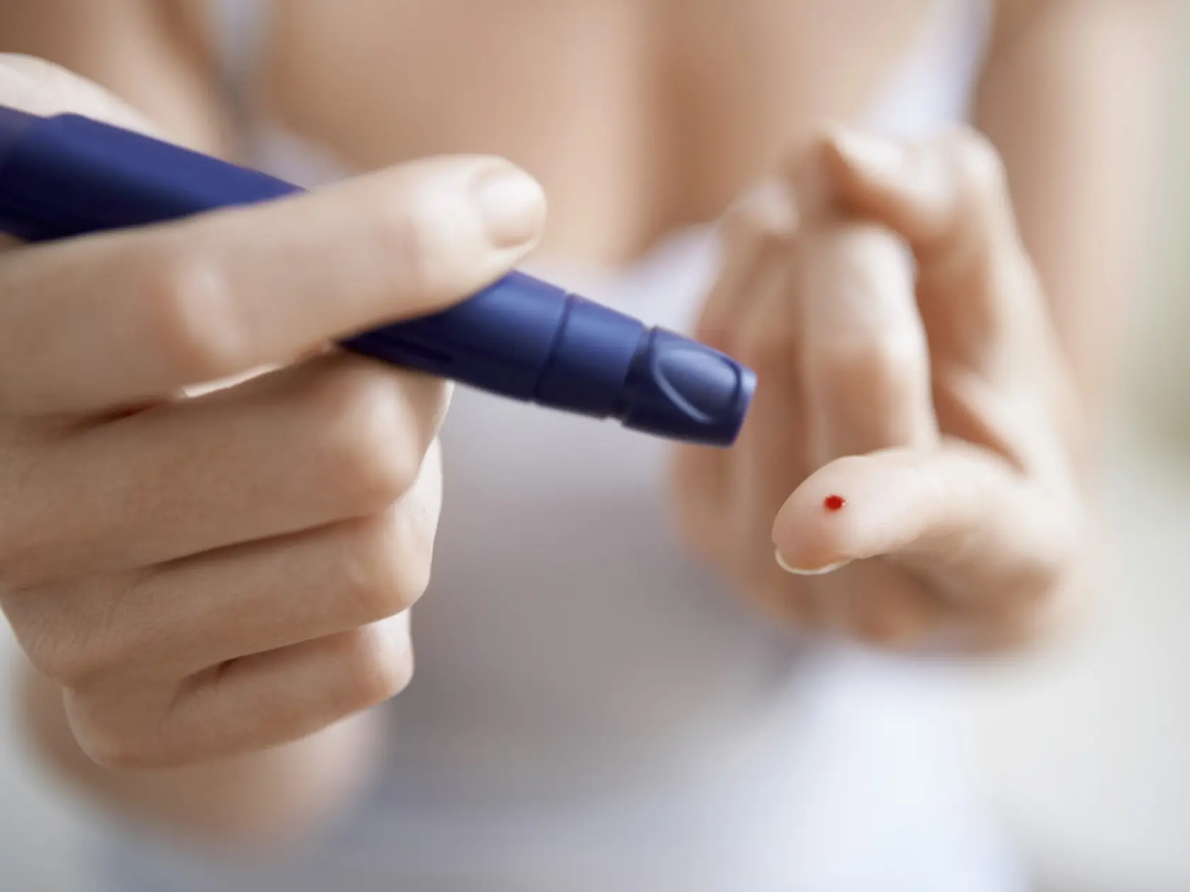 Midsection,Of,Woman,Using,Lancelet,On,Finger