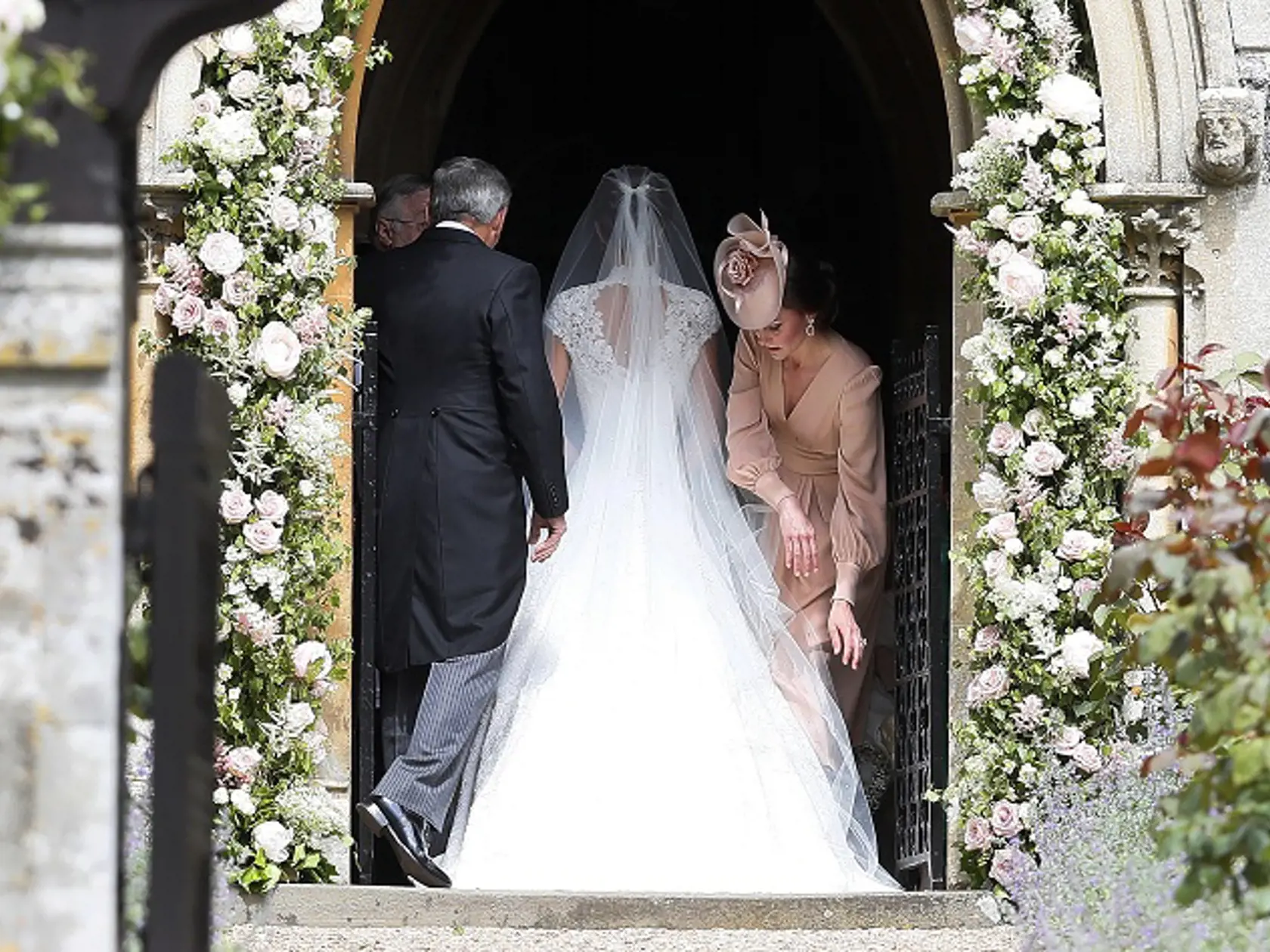 Kate, Duchess of Cambridge, right, arranges the train of her sister of her sister Pippa Middleton as she arrives with her father Michael Middleton for her wedding to James Matthews at St Mark's Church in Englefield, England Saturday, May 20, 2017. Middleton, the sister of Kate, Duchess of Cambridge is to marry hedge fund manager James Matthews in a ceremony Saturday where her niece and nephew Prince George and Princess Charlotte are in the wedding party, along with sister Kate and princes Harry 