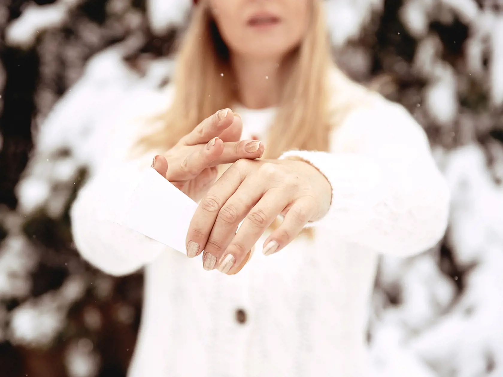 Woman applying cream on skin hands in winter season. Dry and rough skin protection treatment outdoor. Hand Skin Care. Close Up Of Female Hands Applying Cream, Lotion.