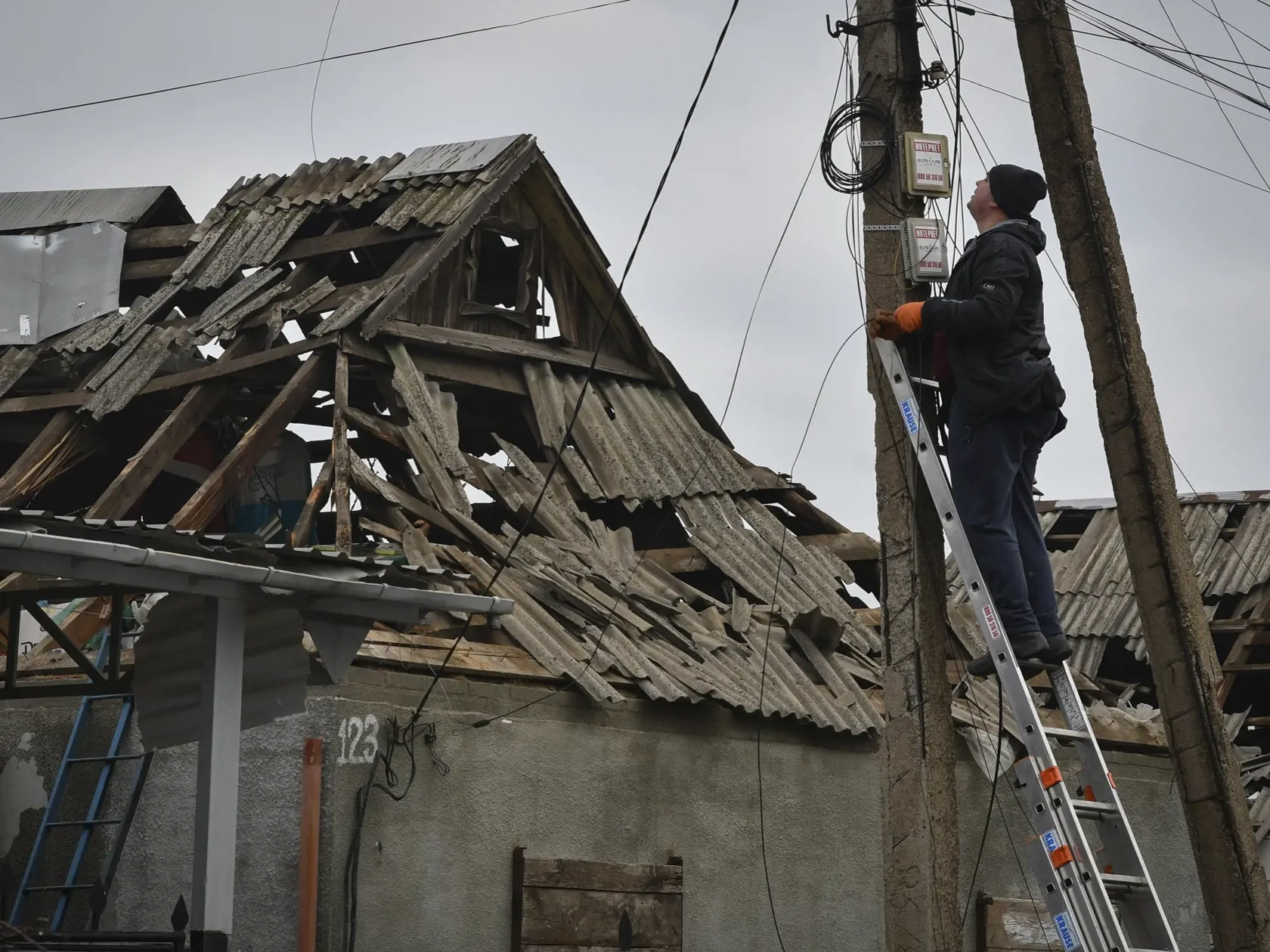 Technik opravuje inernetové pripojenie pri zničenom dome po ruskom ostreľovaní v ukrajinskom meste Kramatorsk 10. novembra 2022.