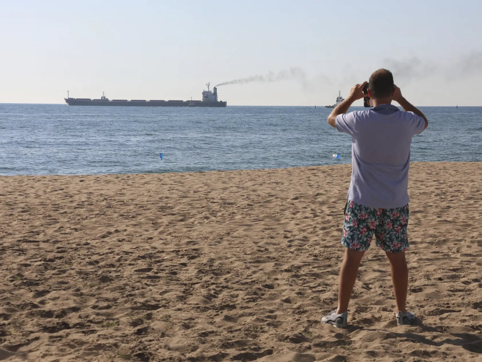 PK 14 Odesa - Muž si fotí nákladnú loď Glory, ktorá pláva z prístavu v ukrajinskej Odese 7. augusta 2022. Z ukrajinských prístavov v Čiernom mori vyplávali v nedeľu na základe dohody o ich odblokovaní štyri lode s nákladom obilia a iných poľnohospodárskych produktov. Lode Mustafa Necati, Star Helena, Glory a Riva Wind vezú takmer 170.000 ton nákladu. FOTO TASR/AP

A man takes a picture as the Glory bulk carrier makes its way from the port in Odesa, Ukraine, Sunday, Aug. 7, 2022. According to Ukr