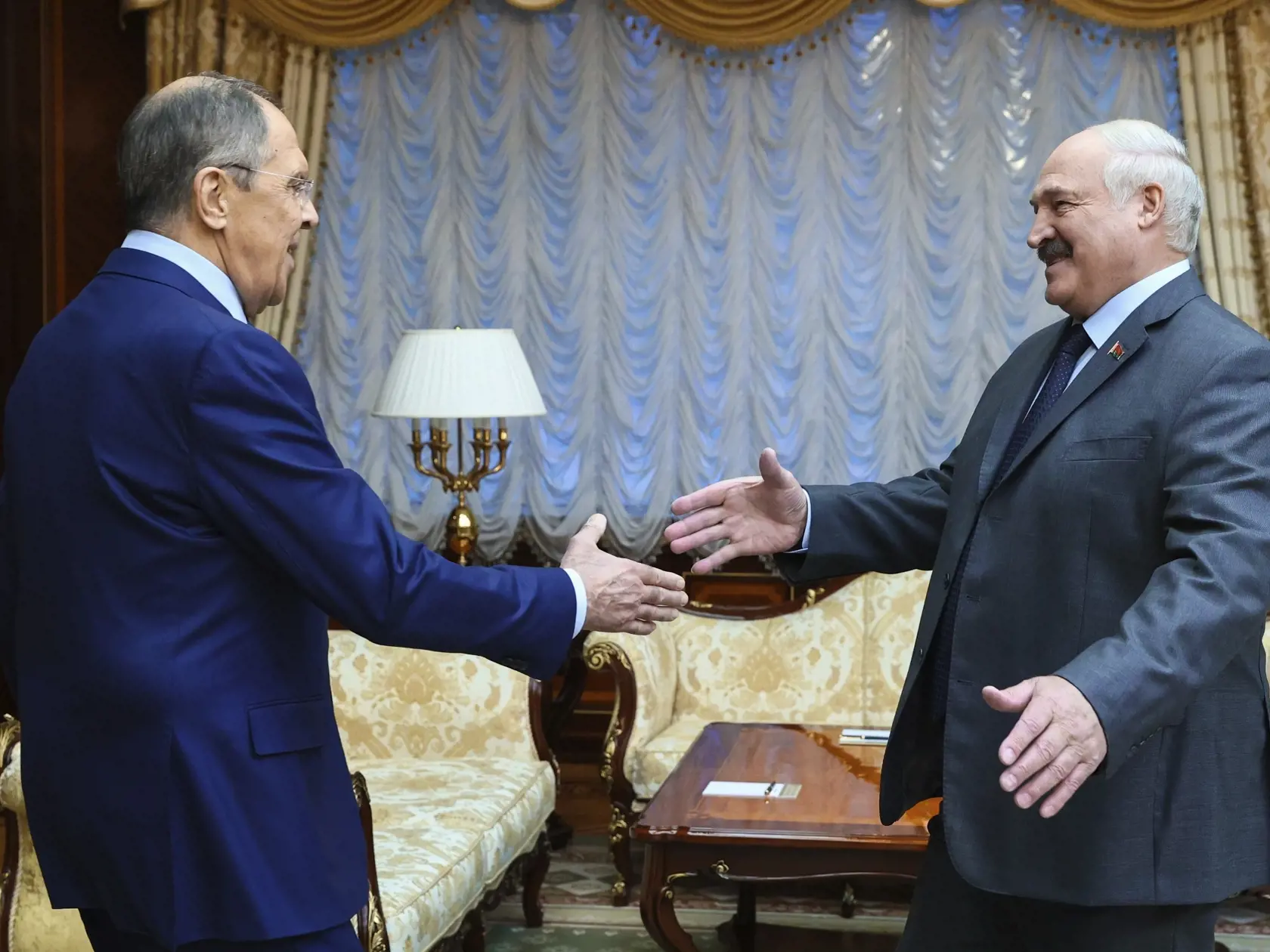 Ruský minister zahraničných vecí Sergej Lavrov (vľavo) a bieloruský prezident Alexander Lukašenko sa vítajú počas stretnutia v Minsku vo štvrtok 19. januára 2023.
