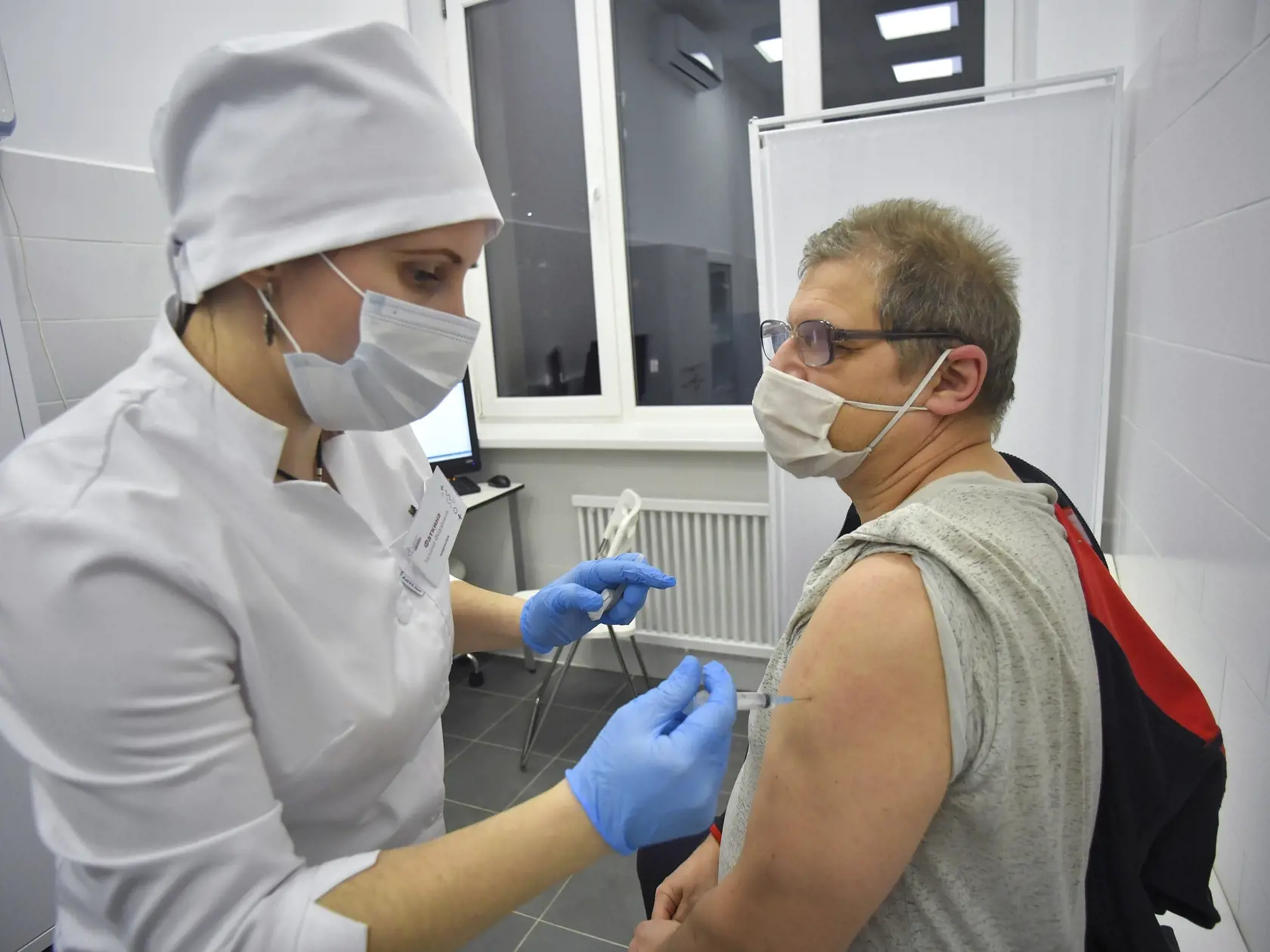 KK18 Moskva - Na snímke starší muž počas očkovania  štátnou vakcínou proti koronavírusu SARS-CoV-2, 28. decembra 2020 v Moskve. Ruské hlavné mesto Moskva od pondelka umožní obyvateľom nad 60 rokov objednať sa na očkovanie štátnou vakcínou proti koronavírusu SARS-CoV-2, uviedla agentúra DPA. K tomuto kroku mesto pristúpilo po tom, čo ruské ministerstvo zdravotníctva schválilo očkovanie starších obyvateľov vakcínou Sputnik V, ktorá úspešne prešla klinickým testovaním. FOTO TASR/AP
A Russian medica