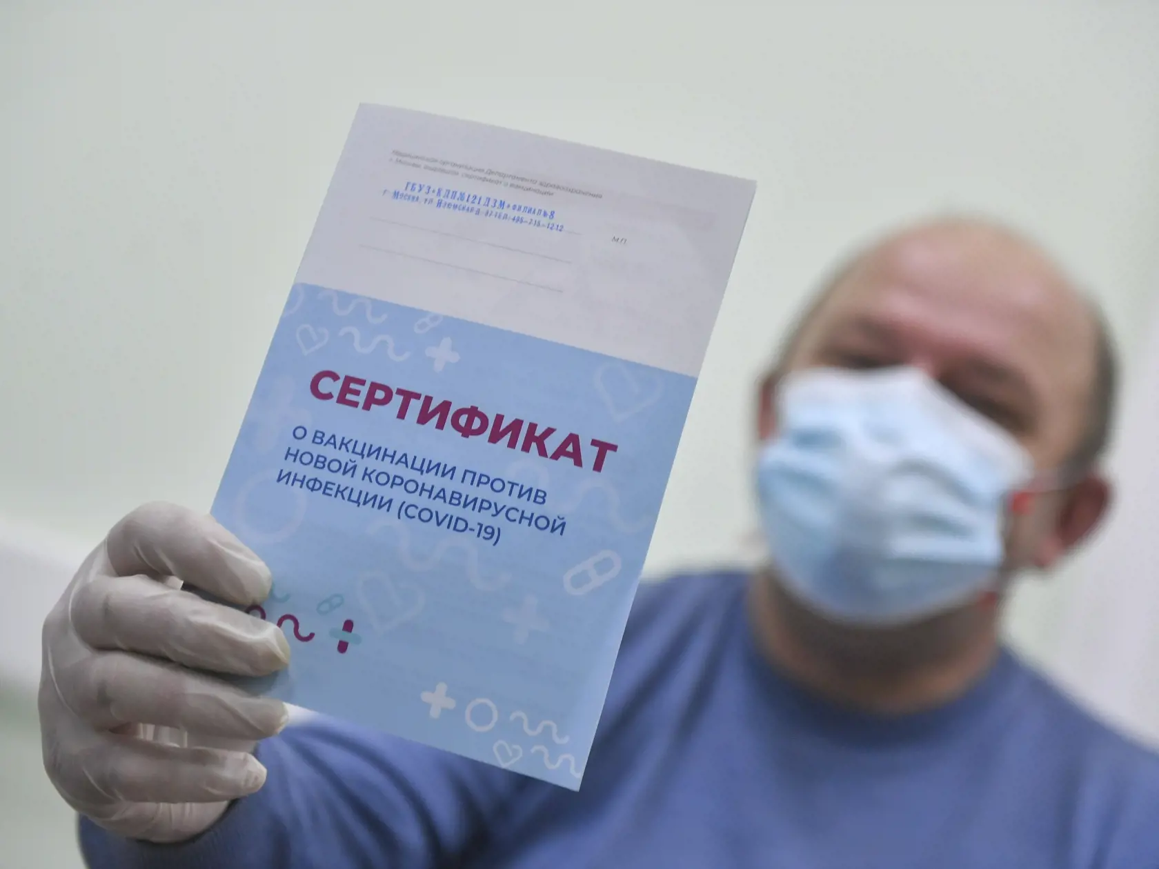 KK21 Moskva - Na snímke muž ukazuje certifikát po očkovaní vakcínou Sputnik V proti koronavírusu SARS-CoV-2, 28. decembra 2020 v Moskve. Ruské hlavné mesto Moskva od pondelka umožní obyvateľom nad 60 rokov objednať sa na očkovanie štátnou vakcínou proti koronavírusu SARS-CoV-2, uviedla agentúra DPA. K tomuto kroku mesto pristúpilo po tom, čo ruské ministerstvo zdravotníctva schválilo očkovanie starších obyvateľov vakcínou Sputnik V, ktorá úspešne prešla klinickým testovaním. FOTO TASR/AP
A man s