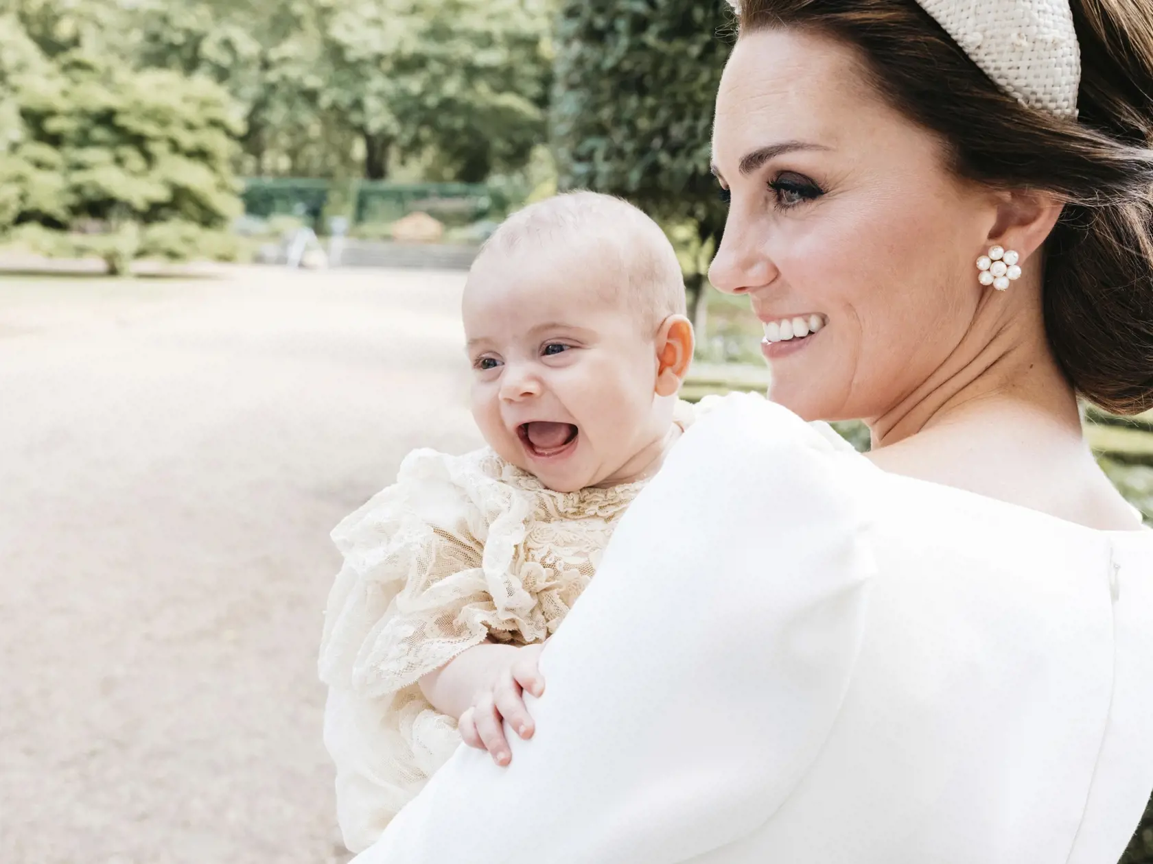 In this Monday, July 9, 2018 photo made available by Kensington Palace, Kate, the Duchess of Cambridge poses for a photo with Prince Louis in the garden of Clarence House, following Prince Louis's baptism at the Chapel Royal, St. James's Palace, in London. (Matt Porteous/Kensington Palace via AP)