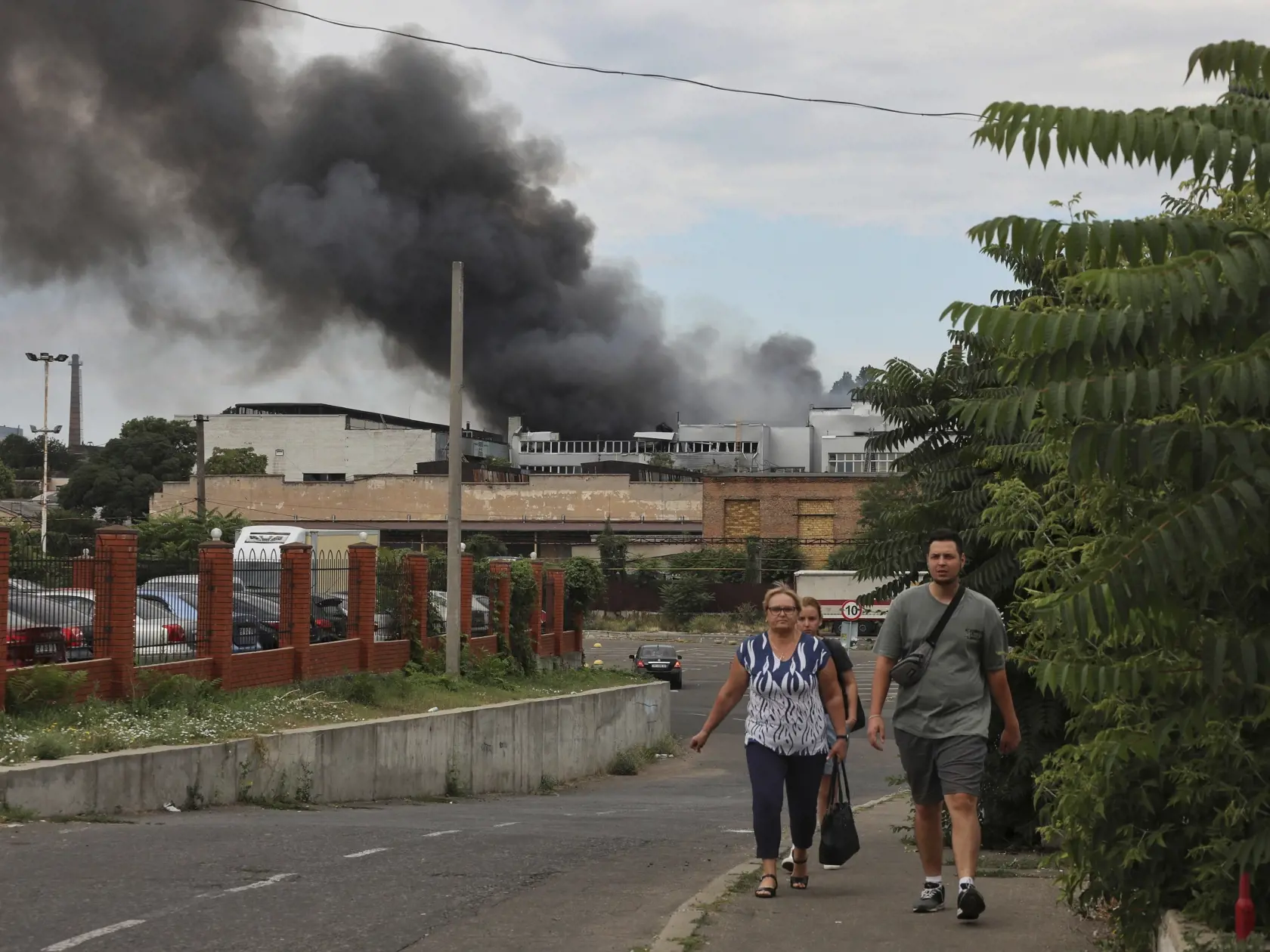 KK30 Odesa - Ľudia kráčajú pol ulici v pozadí dym stúpa k oblohe po ostreľovaní v ukrajinskej Odese 16. júla 2022. FOTO TASR/AP
People walk in a street as smoke rises in the air after shelling in Odesa, Ukraine, Saturday, July 16, 2022. (AP Photo/Nina Lyashonok)