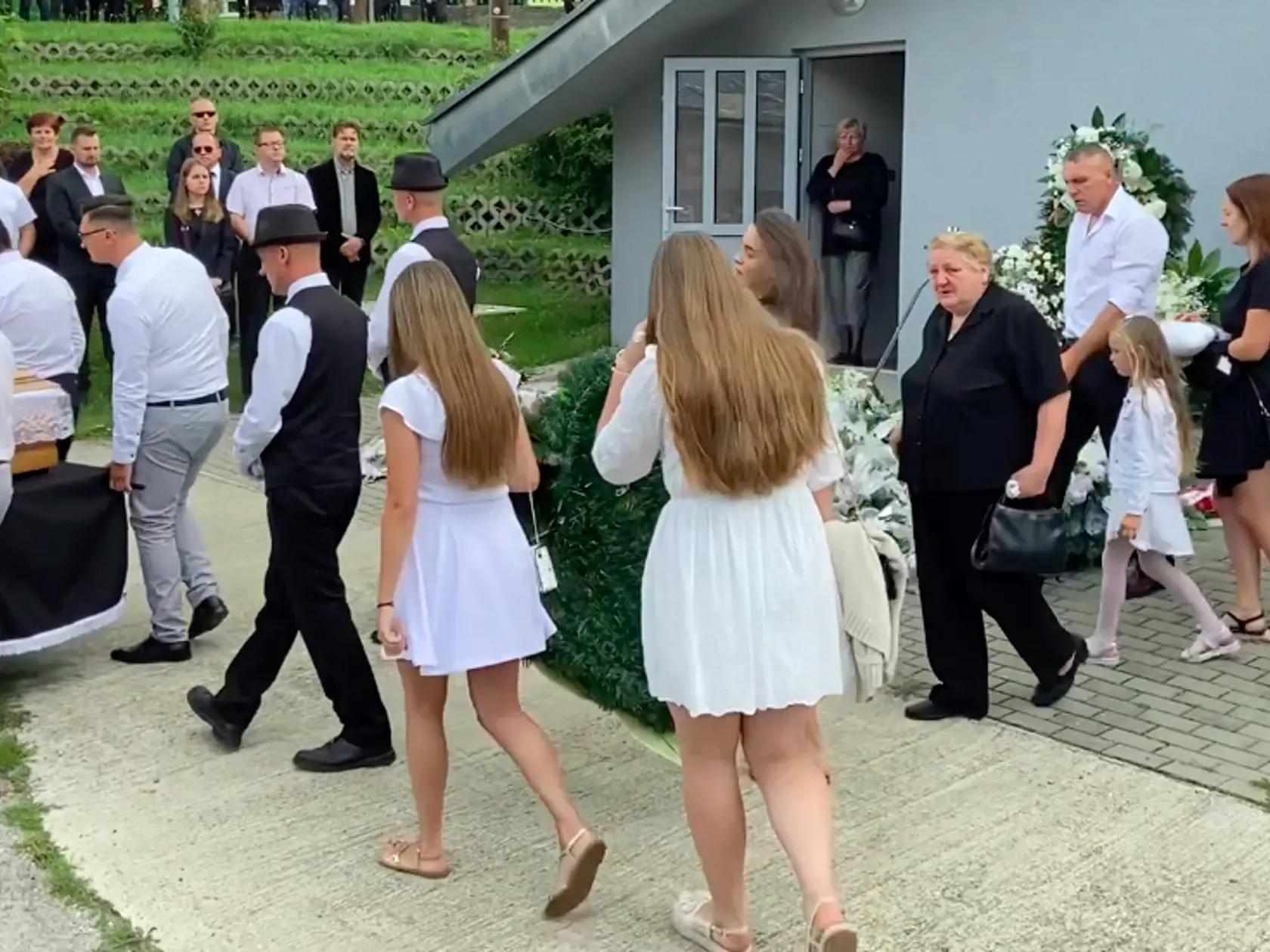 Truhlu s domu smútku vyniesli jeho spoluhráči, za nimi kráčali členky Dievčenského tria, ktoré s kapelou od roku 2018 hrávali. Niesli veľké kvetinové srdce.
