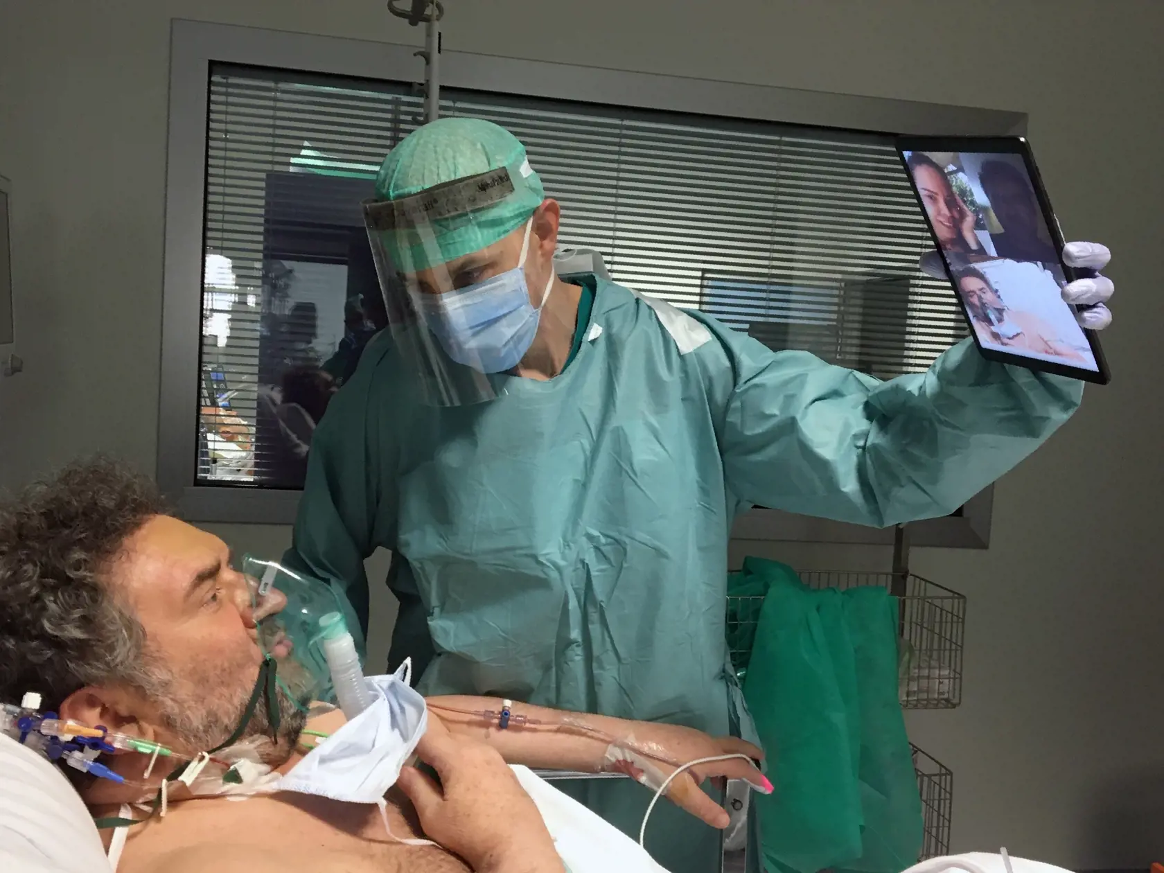 MIK 28 Brescia - Doktor Matteo Flippini drží tablet pre svojho pacienta Alessandra Mattinzoliho aby sa porozprával so svojimi príbuznými prostredníctvom videokonferenčného hovoru v nemocnici Spedali Civili v Brescii v Taliansku 19. marca 2020. FOTO TASR/AP

In this photo taken on Thursday, March 19, 2020, Doctor Matteo Flippini holds a tablet for patient Alessandro Mattinzoli to talk to his relatives via video conference, in the ICU room of the Spedali Civili hospital in Brescia, northern Italy.