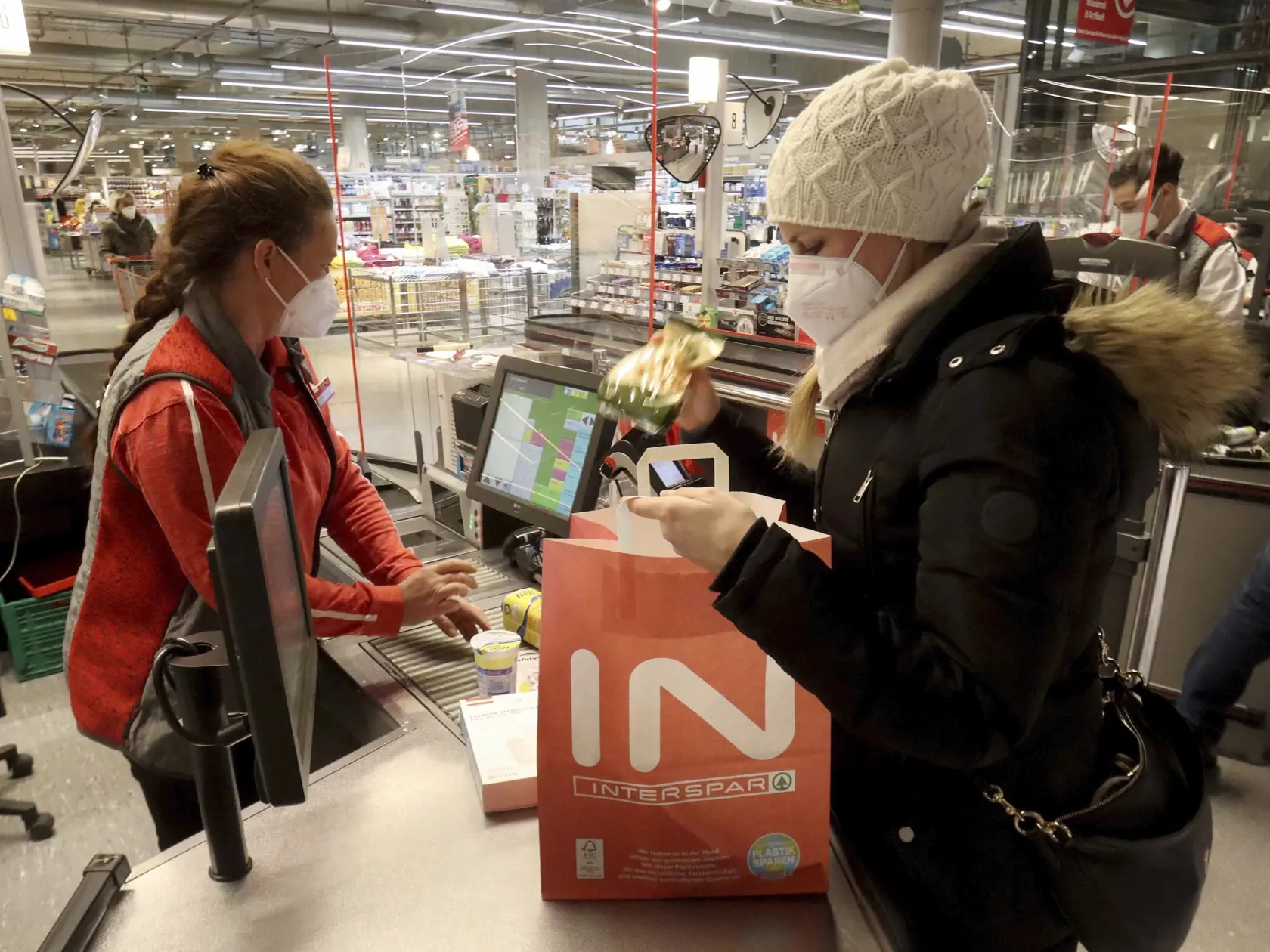 WA 26 Viedeň - Zákazníčka a predavačka sa chránia respirátorom FFP2 pri pokladni v supermarkete vo Viedni v pondelok 25. januára 2021. V Rakúsku začala od pondelka platiť povinnosť nosenia respirátorov triedy FFP2 v obchodoch a hromadnej doprave. FOTO TASR/AP
People wear an FFP2 protective mask when shopping in a supermarket in Vienna, Austria, Monday, Jan. 25, 2021. Austrians have to use medical masks when shopping and in public transport, as masks have become mandatory in Austria. (AP Photo/