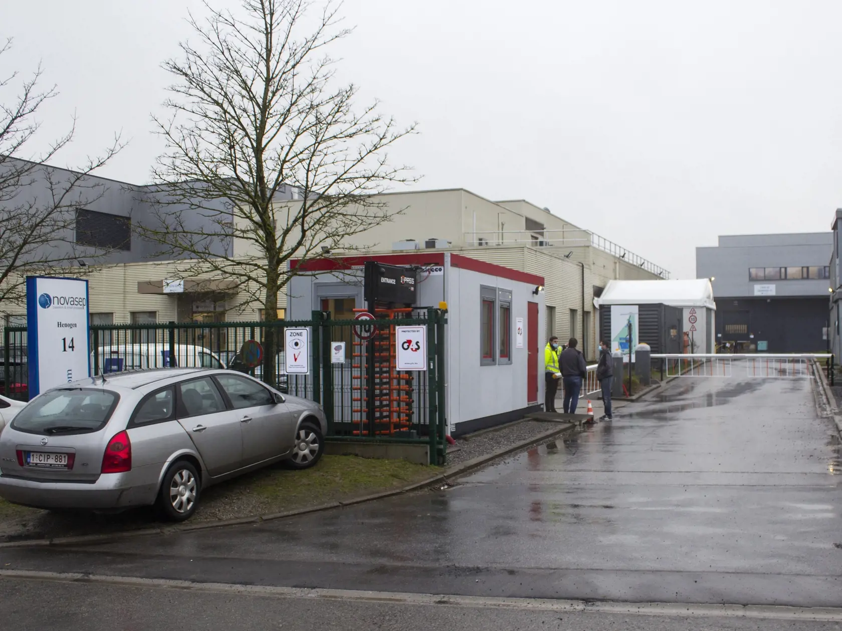 WA 47 Seneffe - Bezpečnostný pracovník sa rozpráva s ľuďmi pred vchodom do závodu Novasep v belgickom meste Seneffe vo štvrtok 28. januára 2021. Belgické úrady vo štvrtok uviedli, že vykonali inšpekciu vo farmaceutickej továrni v Belgicku, aby zistili, či očakávané oneskorenia v dodávkach vakcíny proti ochoreniu COVID-19 od spoločnosti AstraZeneca, súvisia s výrobnými problémami. Továreň Novasep v meste Seneffe je súčasťou európskeho reťazca na výrobu vakcíny proti ochoreniu COVID-19, ktorú vyvi
