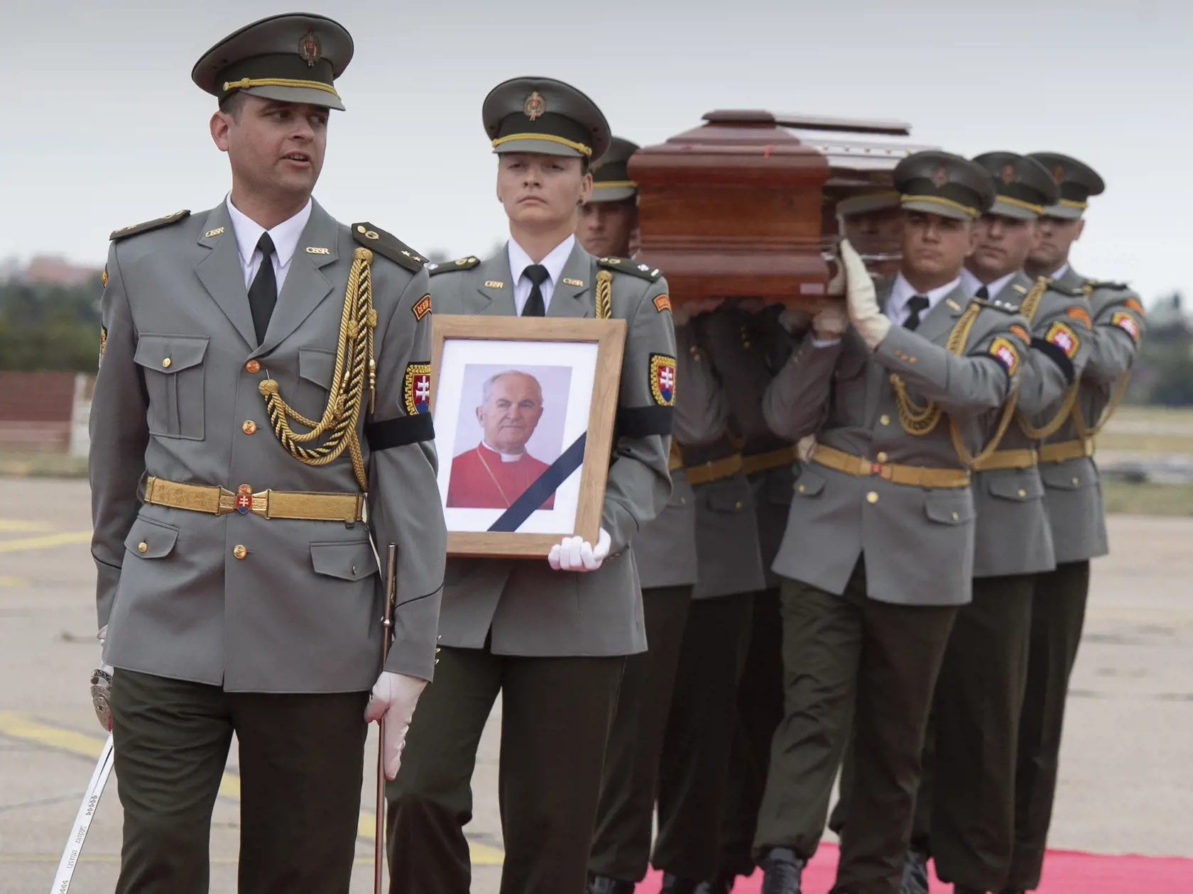 Pozostatky kardinála Jozefa Tomka sú už na Slovensku. Lietadlo s rakvou priletelo vo štvrtok 11. augusta 2022 z Vatikánu na bratislavské letisko M. R. Štefánika. Tomko bol najstarším členom kolégia kardinálov. Zomrel vo veku 98 rokov v pondelok (8. 8.) vo svojom byte v Ríme. Na snímke čestná stráž nesie rakvu s pozostatkami kardinála Jozefa Tomku na bratislavskom letisku M.R. Štefánika. FOTO TASR - Pavel Neubauer