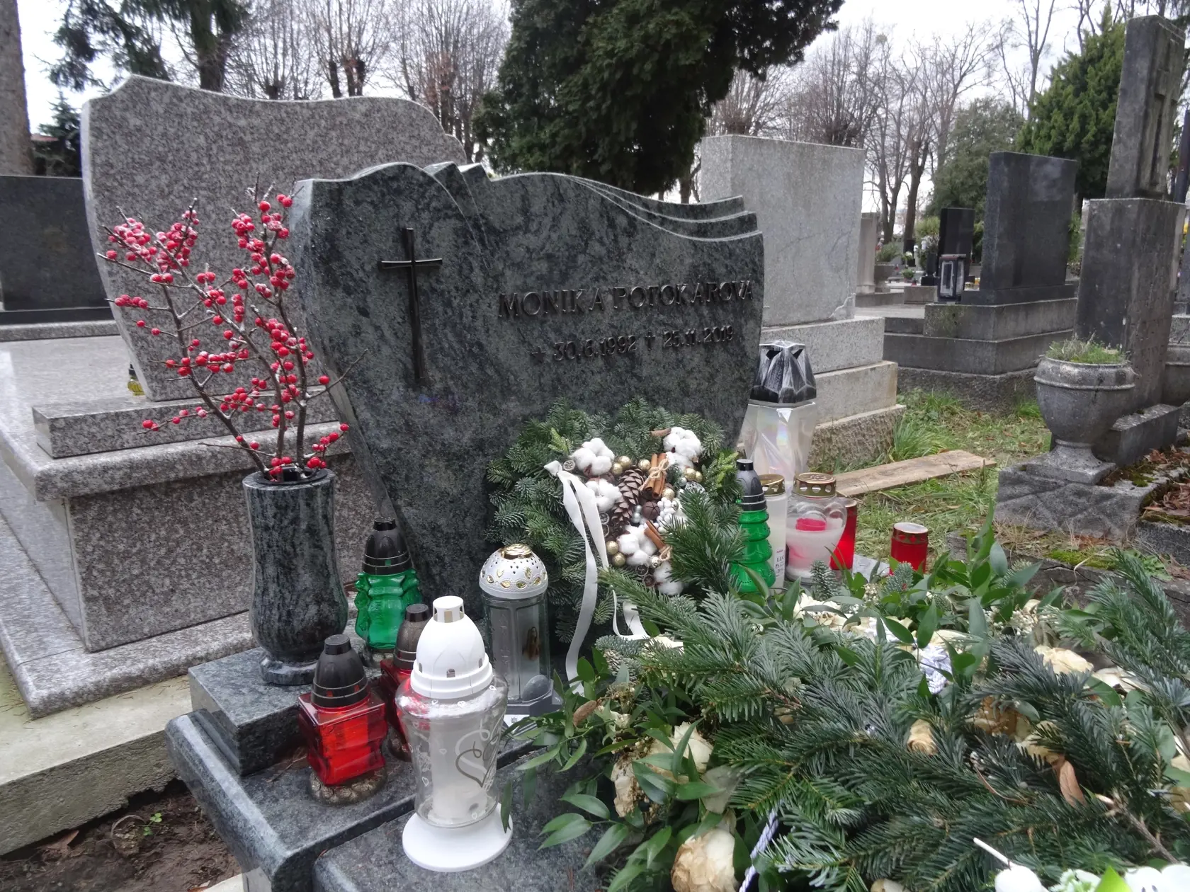 Veniec z bielych ruží v tvare srdca je na hrobe od pohrebu aj napriek tomu, že kvety už zvädli. Zrejme kvôli efektu ich niekto prekryl konárikmi čečiny. (archív)