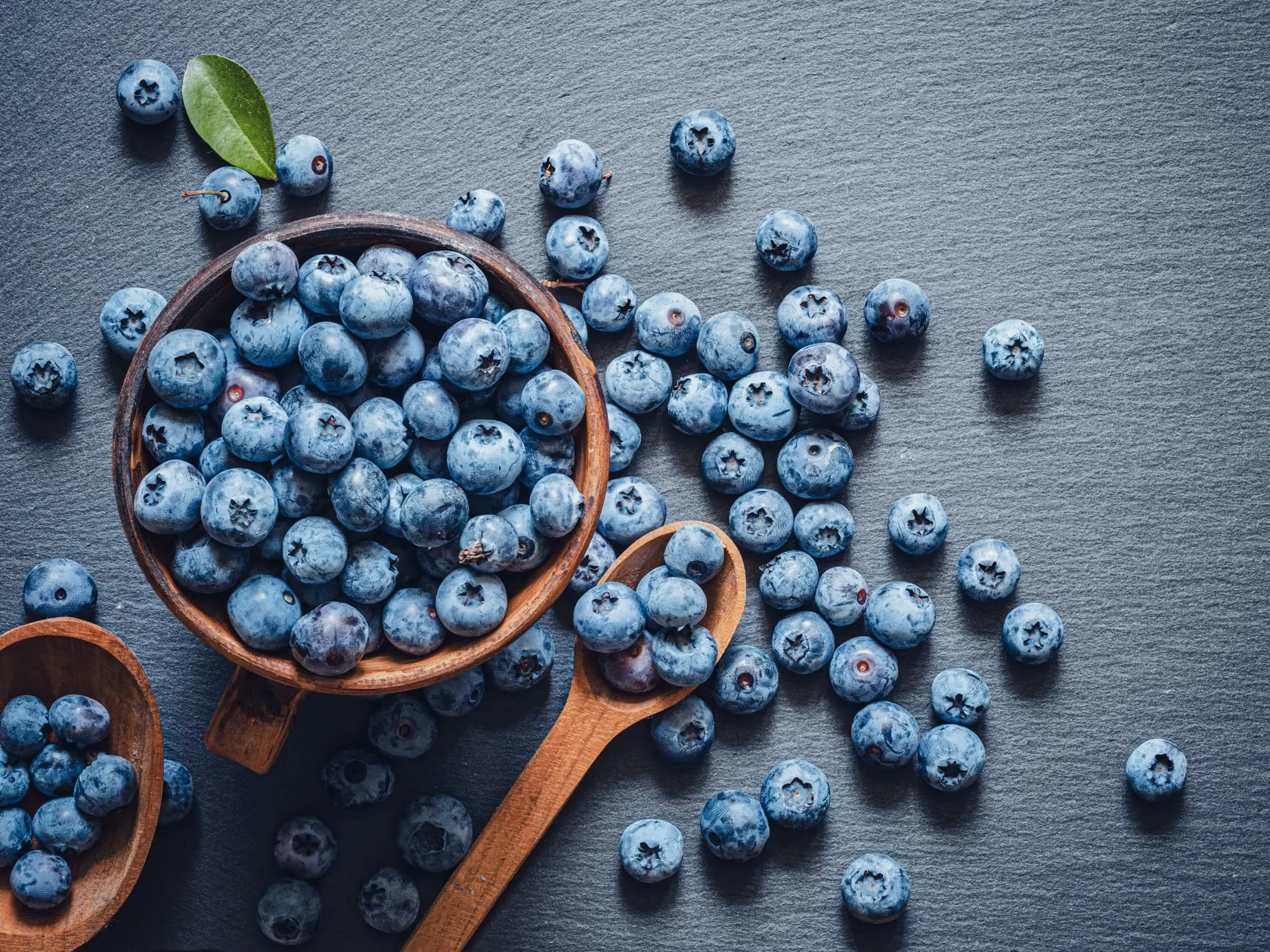 The,Blueberries,In,A,Wooden,Bowl,And,Spoon,And,Scattered