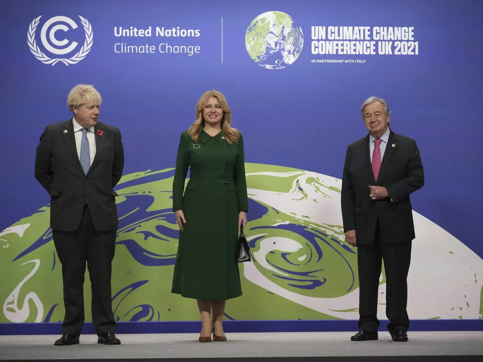 KK5 Glasgow - Zľava britský premiér Boris Johnson, slovenská prezidentka Zuzana Čaputová a generálny tajomník OSN António Guterres prichádzajú na klimatický summit COP26 v škótskom Glasgowe v pondelok 1. novembra 2021.  V Glasgowe sa v nedeľu oficiálne začal klimatický summit OSN COP26, ktorý potrvá do 12. novembra. FOTO TASR/AP
UN Secretary-General Antonio Guterres, right, greets Slovak President Zuzana Caputova as British Prime Minister Boris Johnson looks on, at the COP26 U.N. Climate Summit 