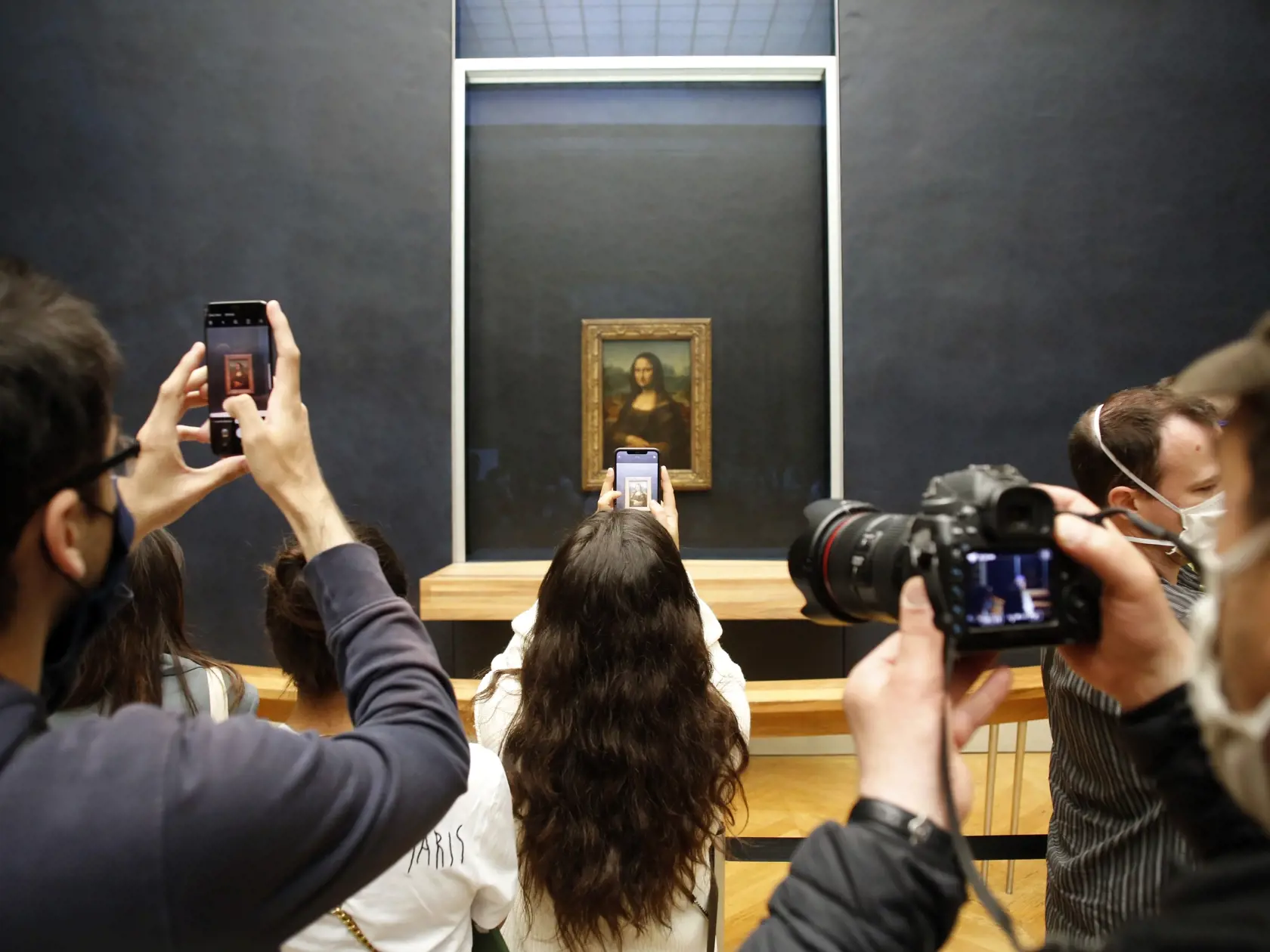 KK30 Paríž - Návštevníci si fotografujú obraz Mona Líza od Leonarda da Vinciho počas znovuotvorenia múzea Louvre v Paríži 6. júla 2020. Parížsky Louvre, najnavštevovanejšie múzeum na svete, otvoril v pondelok väčšinu svojich expozícií po štvormesačnej prestávke spôsobenej pandémiou koronavírusu. Návštevníci budú musieť mať na tvári rúška a ich počet bude obmedzený. Vstupenky si bude potrebné vopred zarezervovať. FOTO TASR/AP
Visitors take photos of the Leonardo da Vinci's painting Mona Lisa, in 