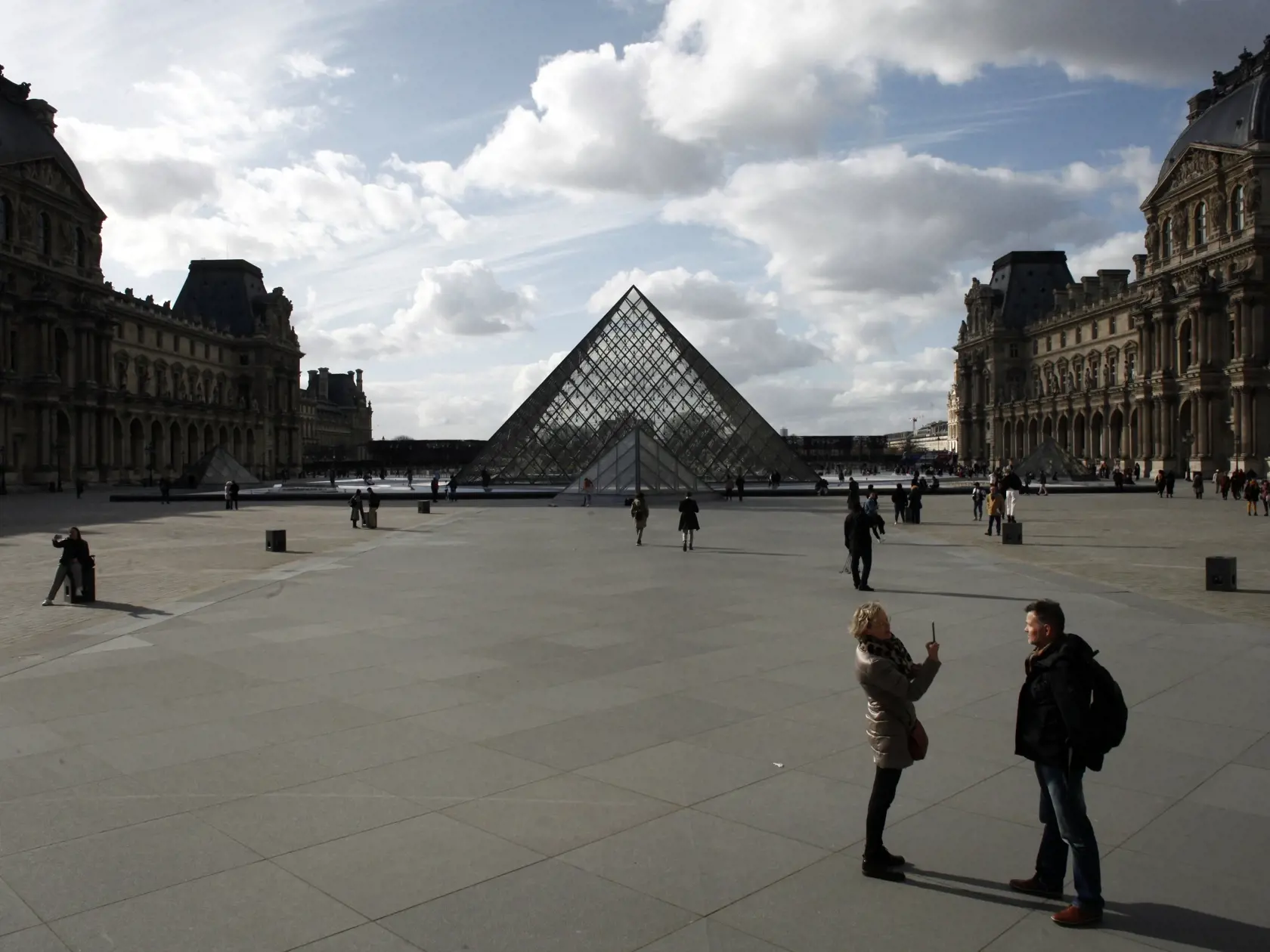 KK13 Paríž - Ľudia kráčajú pred múzeom Louvre v Paríži 13. marca 2020. Parížske múzeum Louvre bude od piatku 13. marca 18.00 h SEČ až do odvolania pre verejnosť zatvorené. Informovalo o tom v piatok francúzske ministerstvo kultúry, ktoré vyzvalo aj ďalšie múzeá a knižnice v krajine, aby v súvislosti s epidémiou koronavírusu SARS-CoV-2 obmedzili alebo prerušili svoje aktivity. FOTO TASR/AP
People walk by the Louvre Museum, in Paris, Friday, March 13, 2020. The Louvre Museum in Paris and the Versa